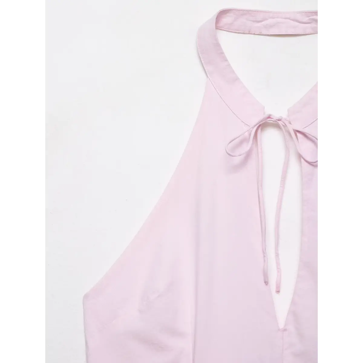 Close-up of the dress's halter neckline, keyhole tie, and fabric texture.