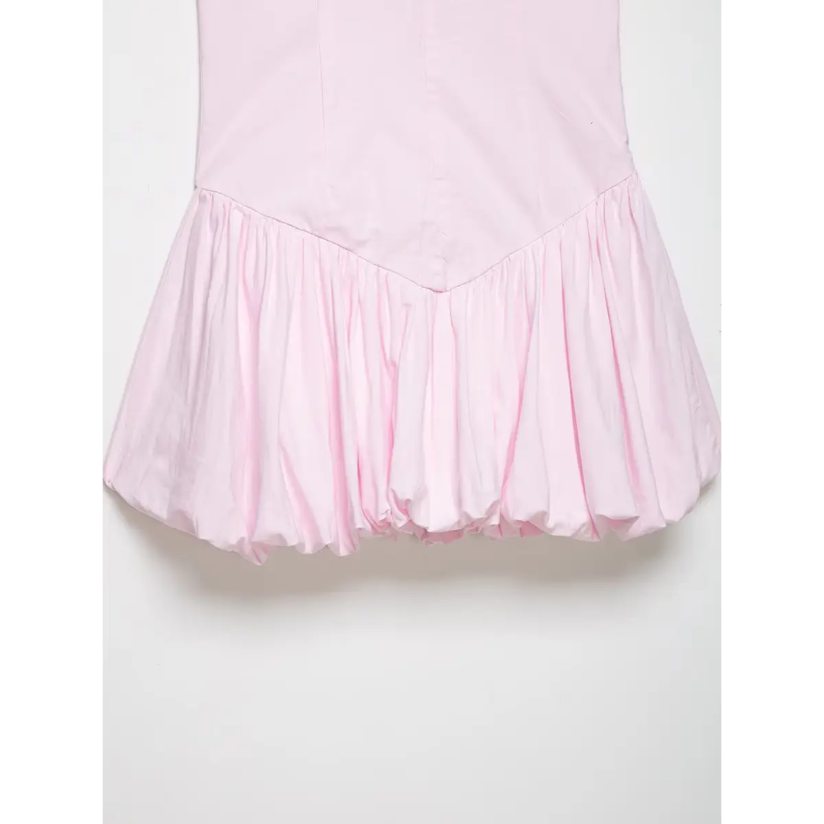 Close-up of the dress's V-shaped waist seam and skirt gathers.