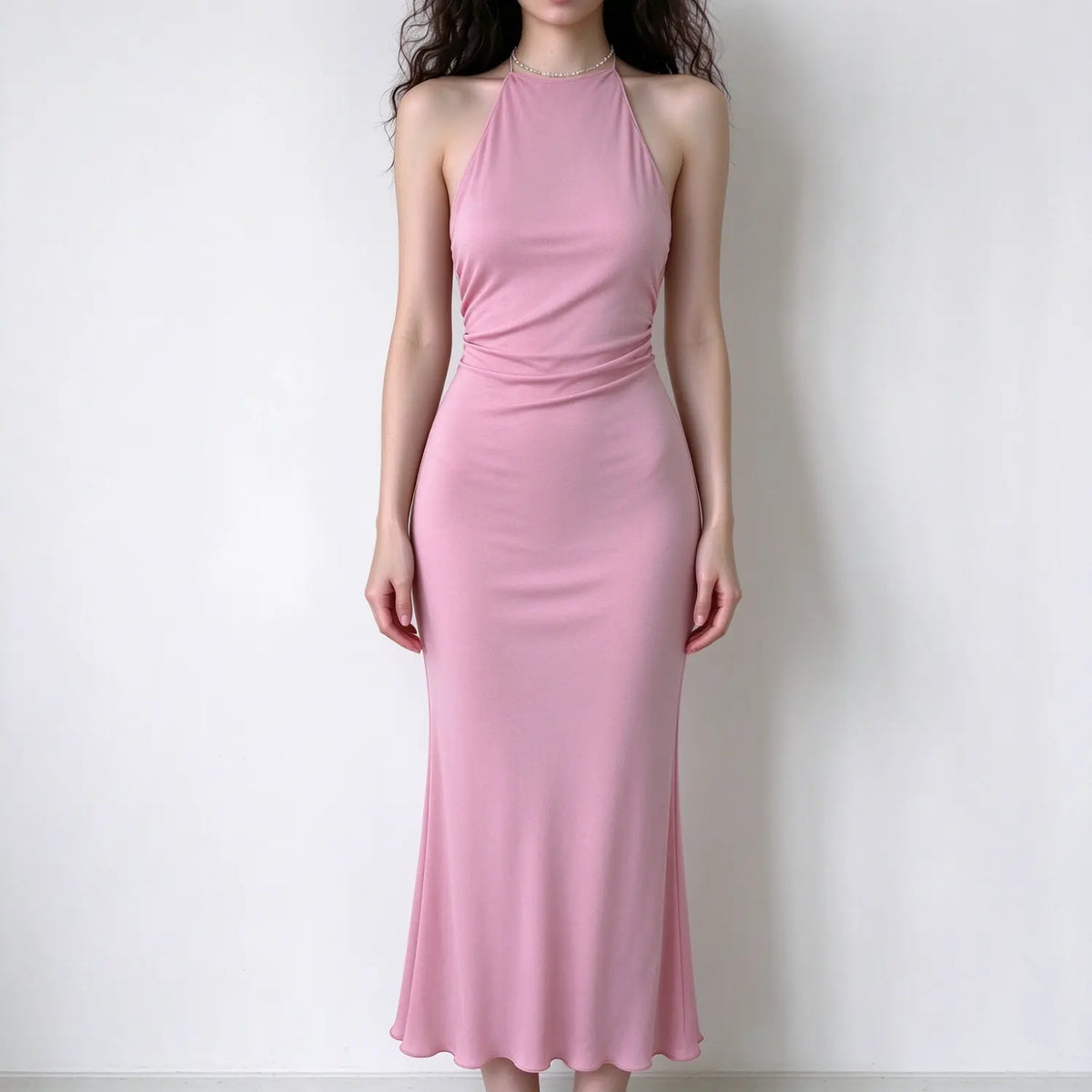 Model wearing pink halter neck maxi dress, ruched waist detail, slim fit mermaid hem, sleek stretch fabric, front view