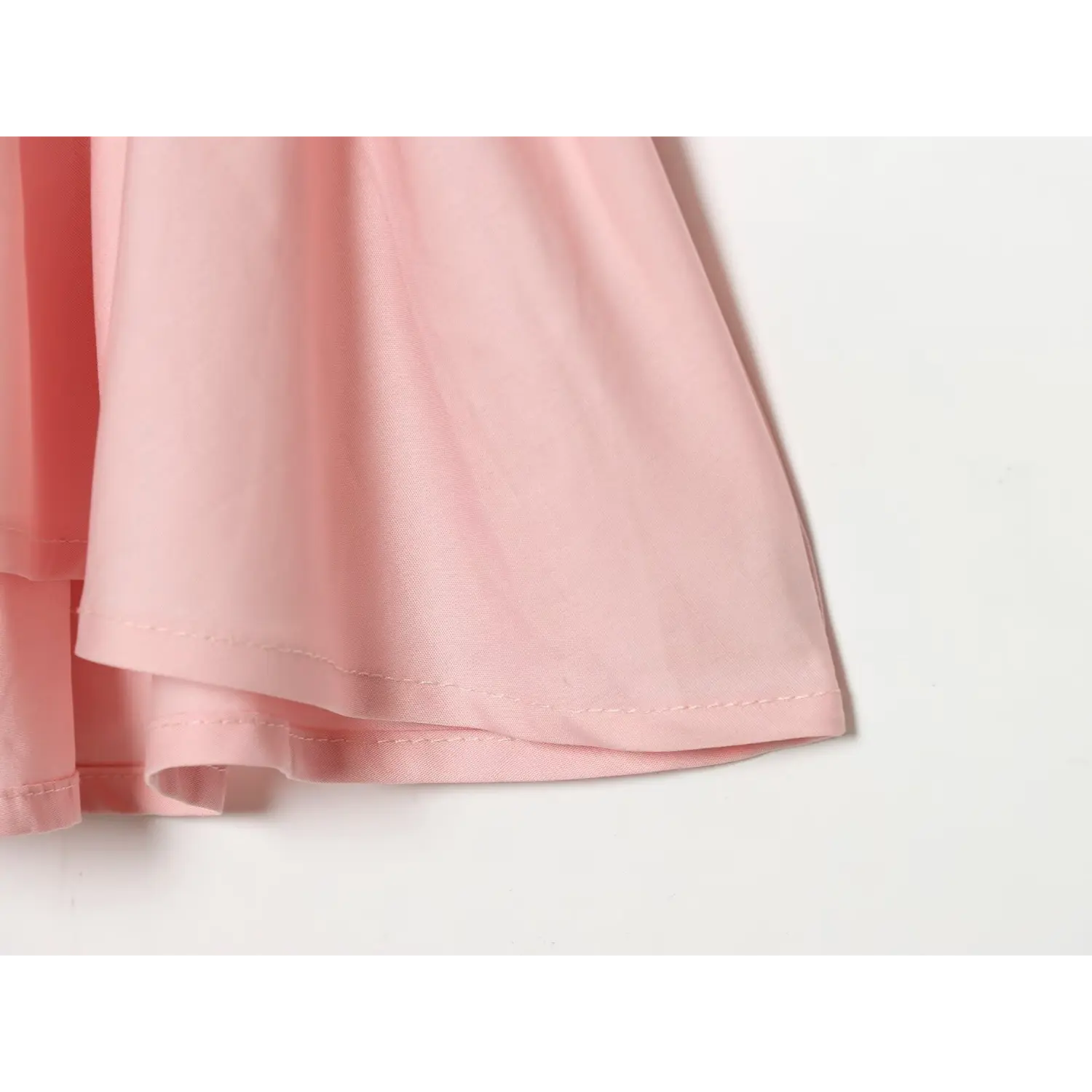 Bottom hem stitching detail of pink halter top, finished seam workmanship