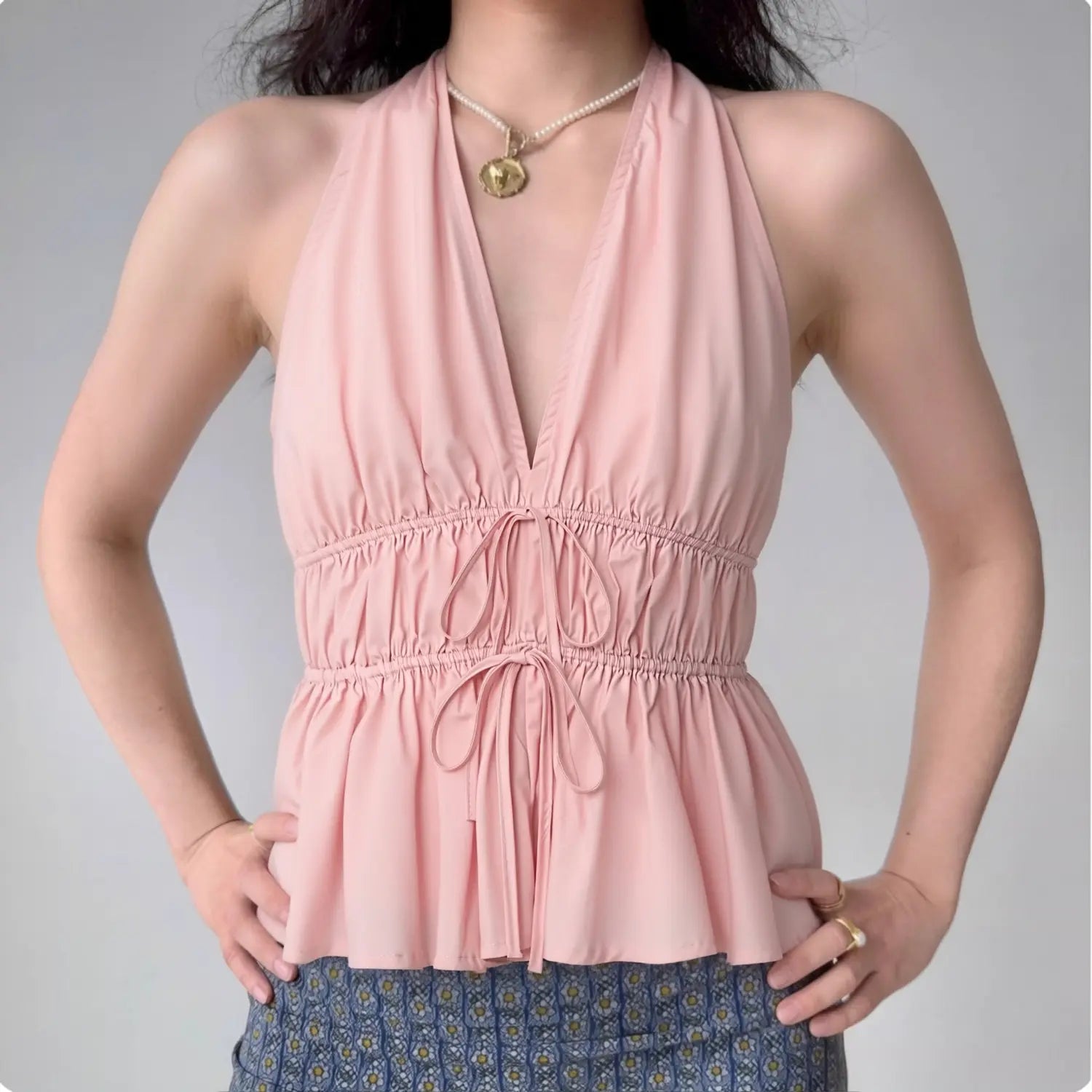 Model front view wearing pink halter peplum top, show silhouette and fit effect
