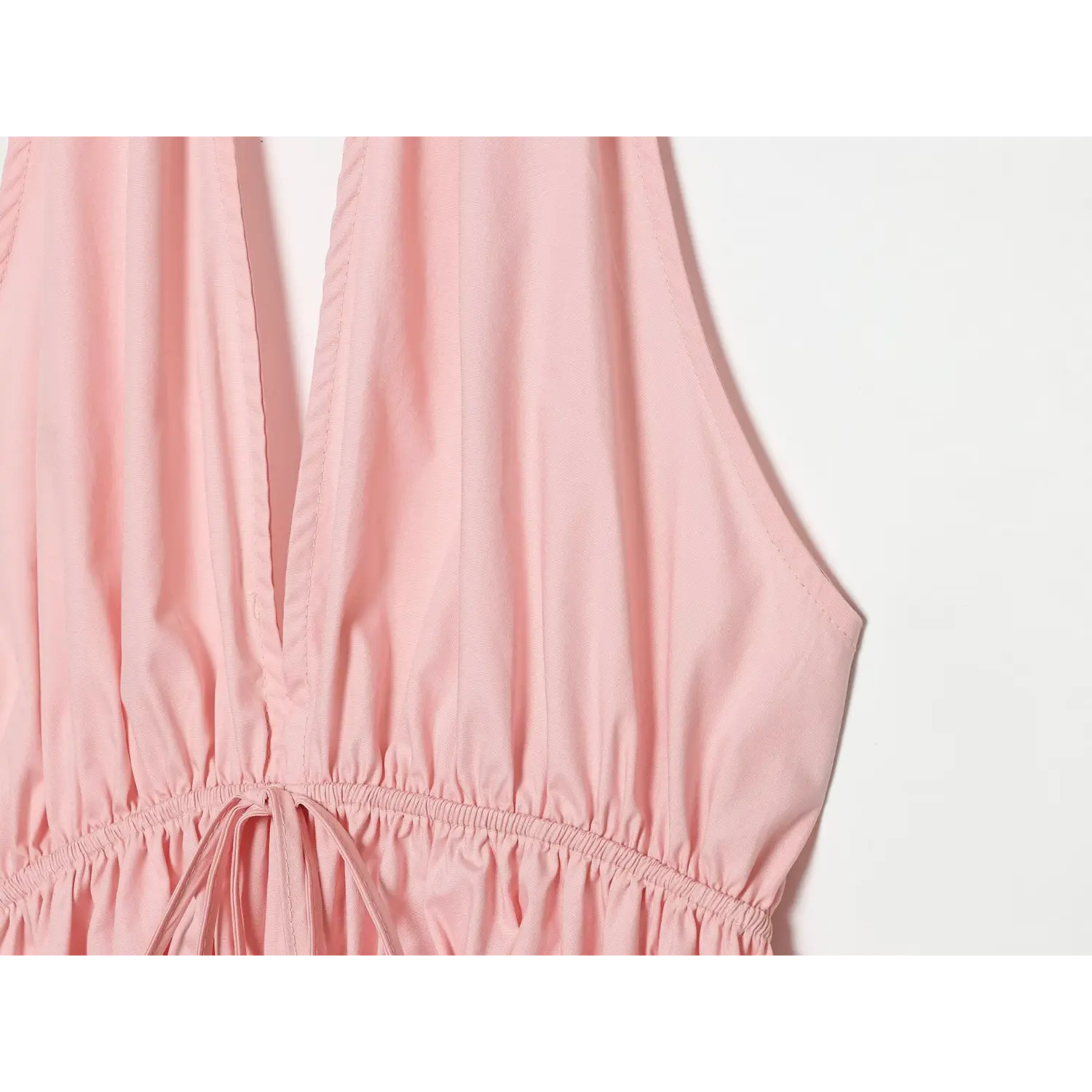 Side close-up of deep V neckline, armhole seam and fabric drape