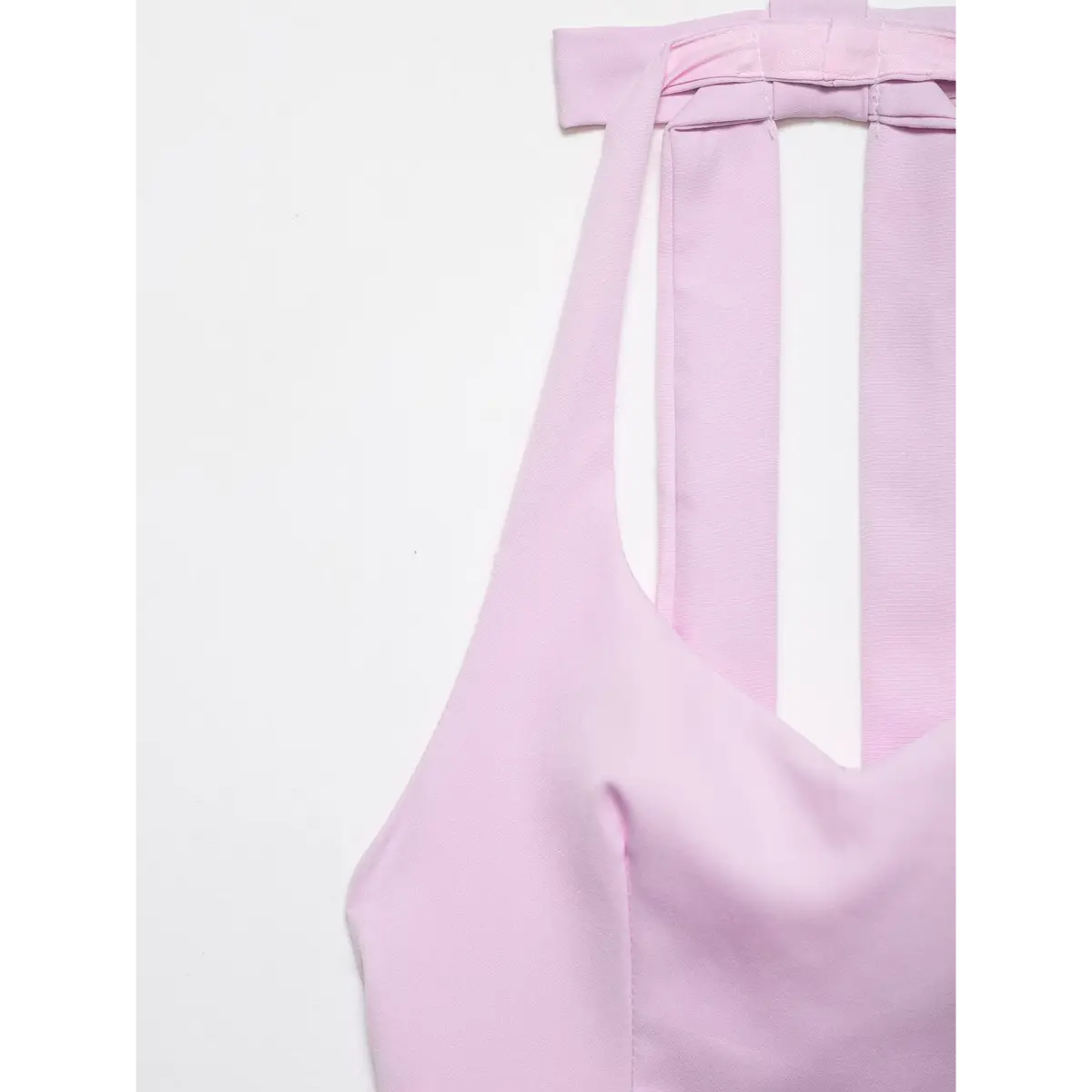 Close-up of the top's neckline, showing the structured bow detail and halter straps.