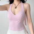 The top styled on a model, highlighting its V-neck, halter straps, and the long tie hanging down the back.