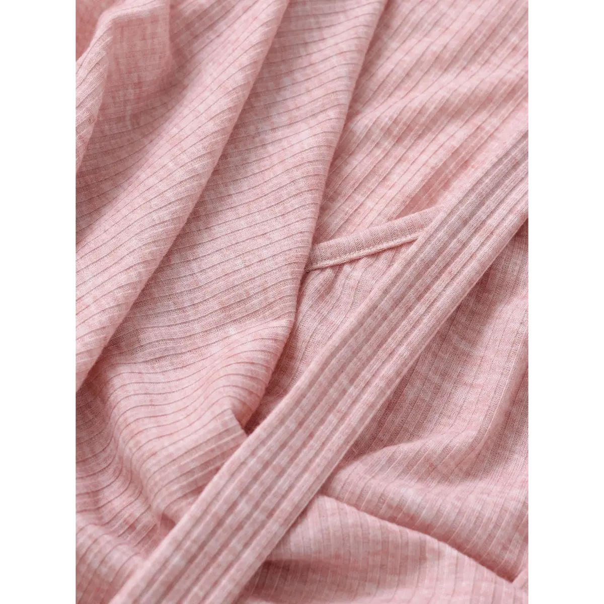 Close-up of the pink ribbed knit fabric texture on a halter wrap top, showing the fine vertical stripes.
