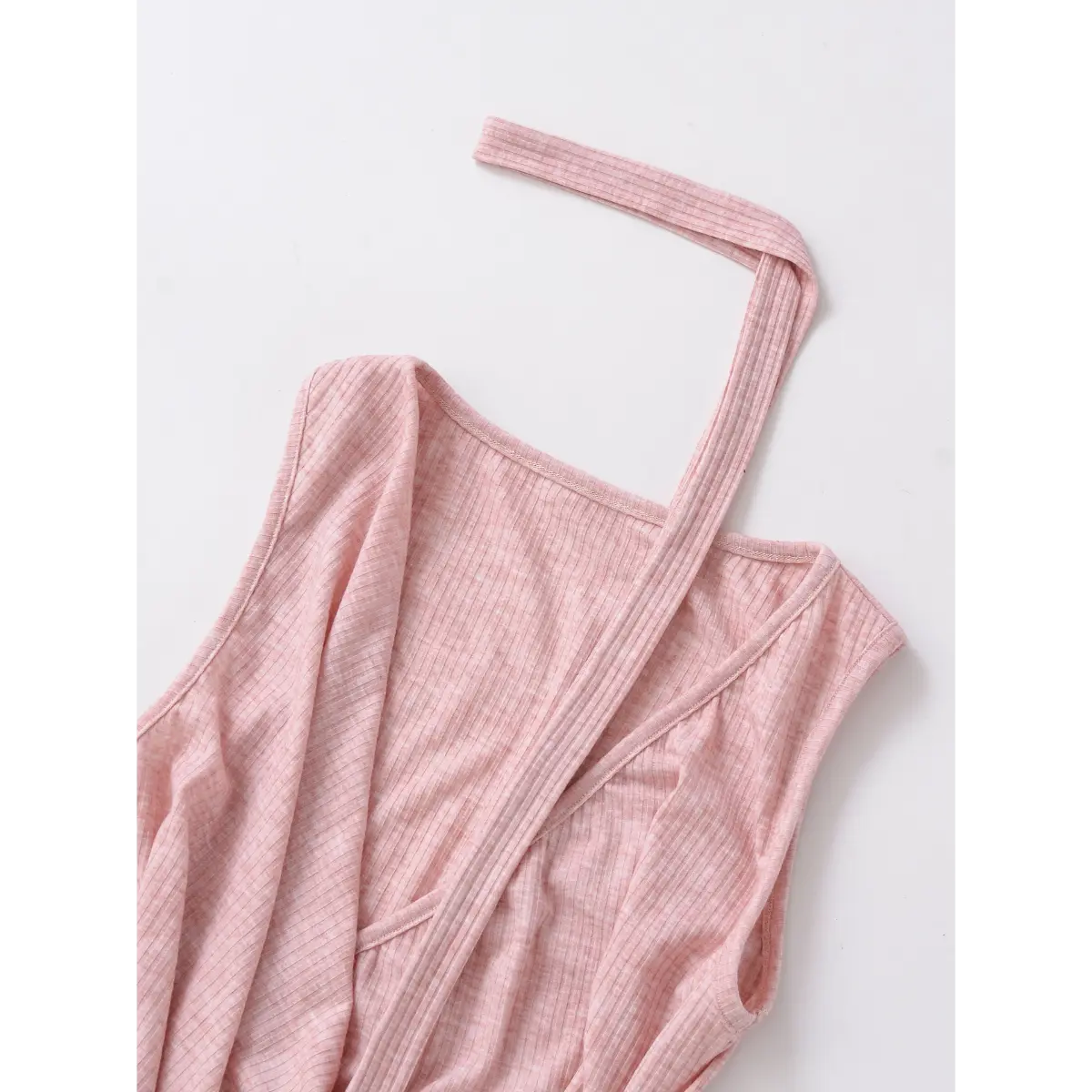 Flat lay view of a pink ribbed halter wrap top, showing the wrap front, choker neckline, and tie strap.