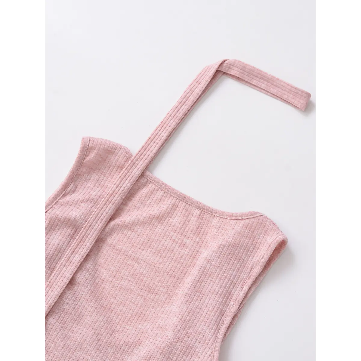 Close-up of the neckline and strap on a pink ribbed halter wrap top, showing the fine vertical texture.
