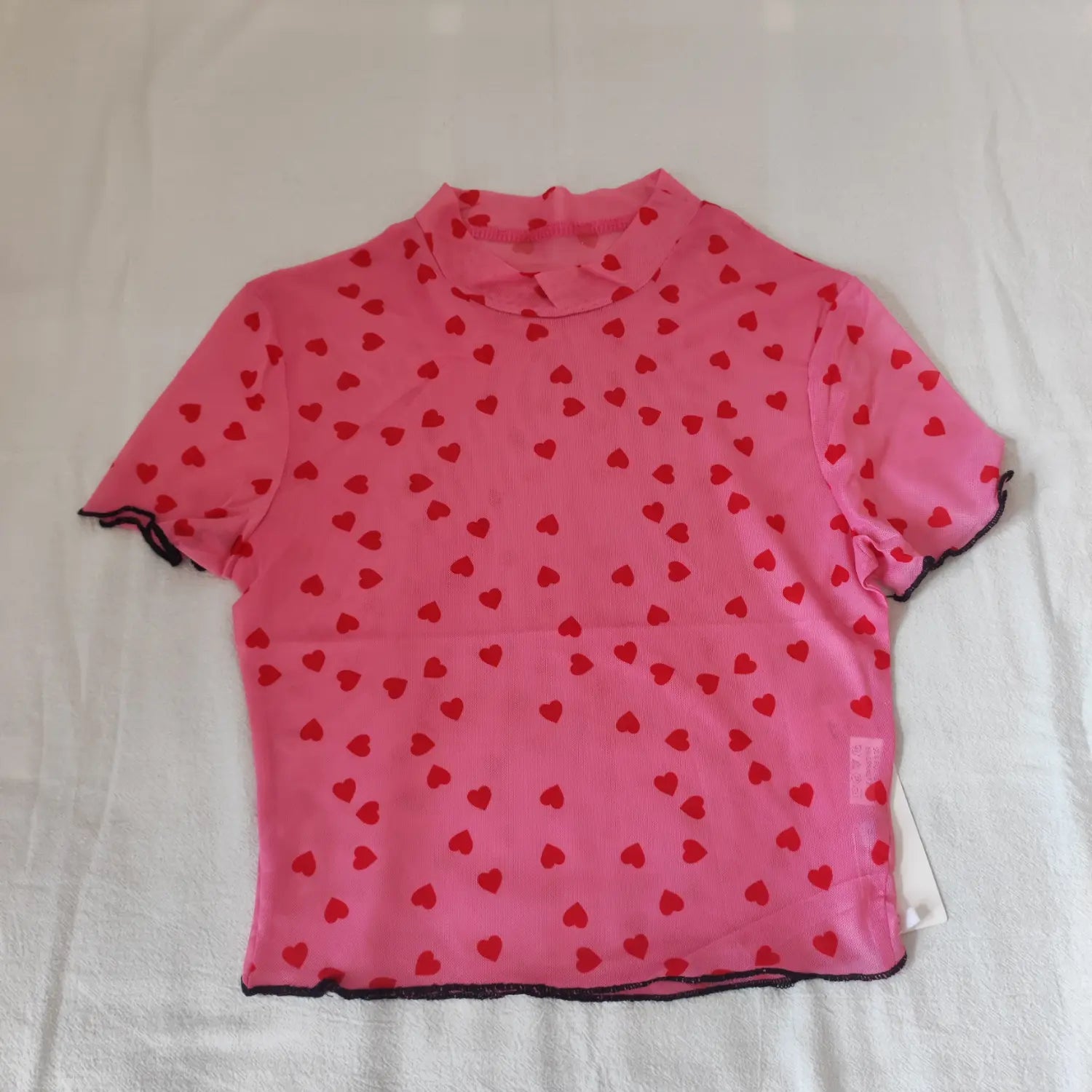 Flat lay front view pink high neck short sleeve mesh top with red heart allover print