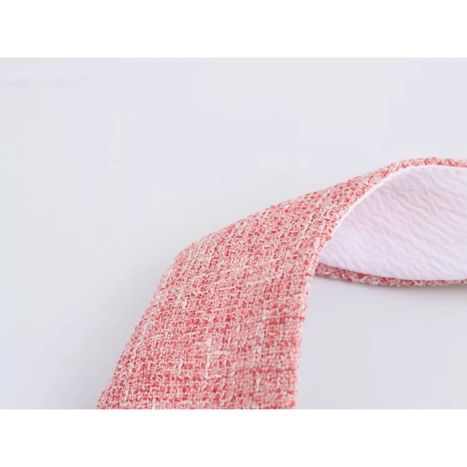 Macro shot mixed pink-white slub tweed woven texture, soft thick tweed, light white lining inside strap edge