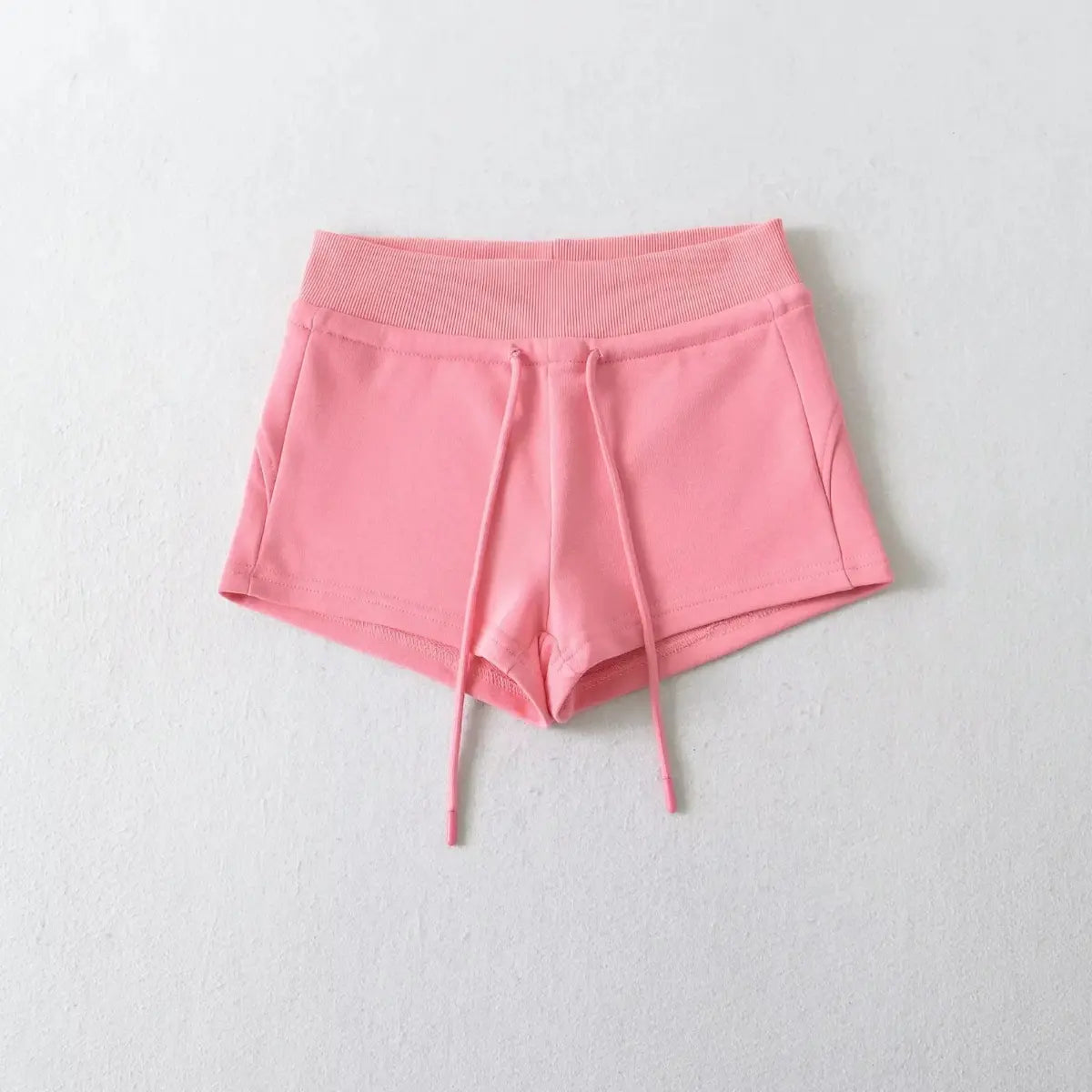 Pink high-waisted drawstring shorts laid flat on a white background, showing the front view.