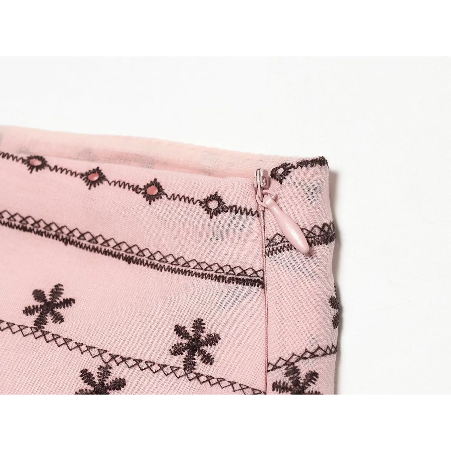 Macro close-up of matching pink invisible zipper teeth and coated pull tab