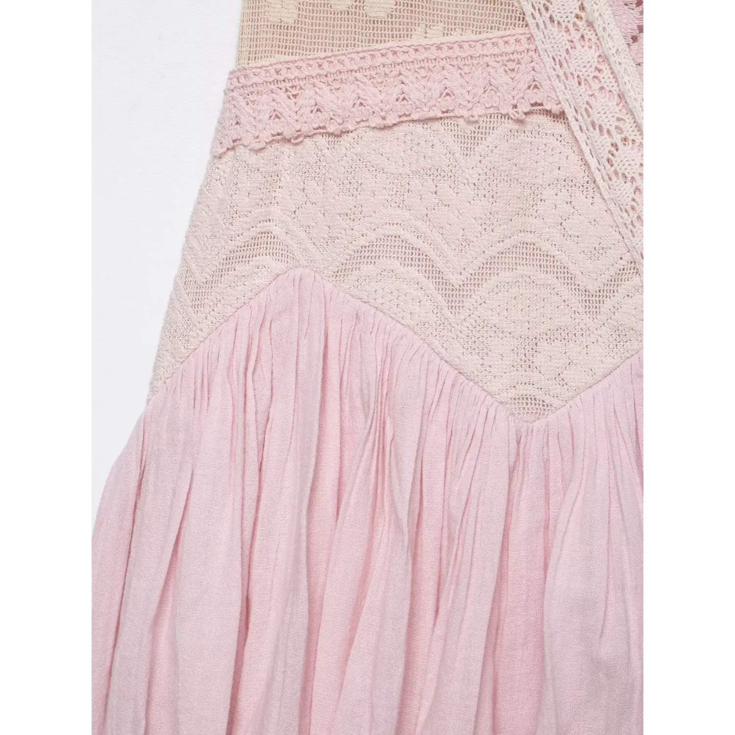 Close-up isolated white background, stitching joint detail between floral lace bodice and gathered pleated bubble mini skirt in pink