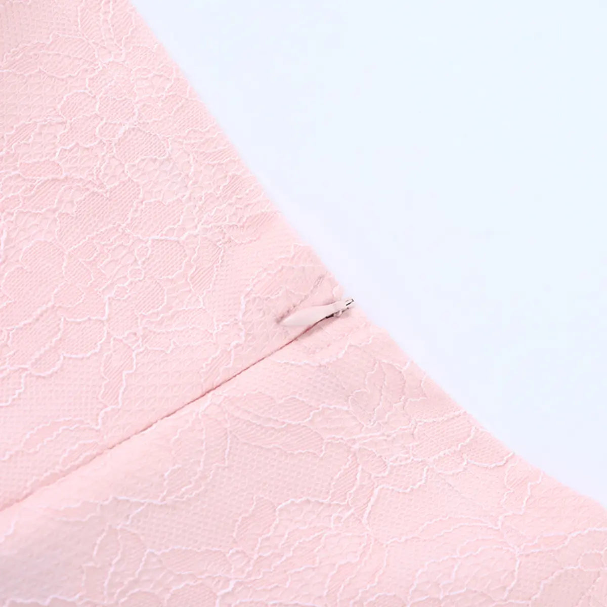 Close-up of the side zipper on the pink lace bustier top, with a matching pink pull
