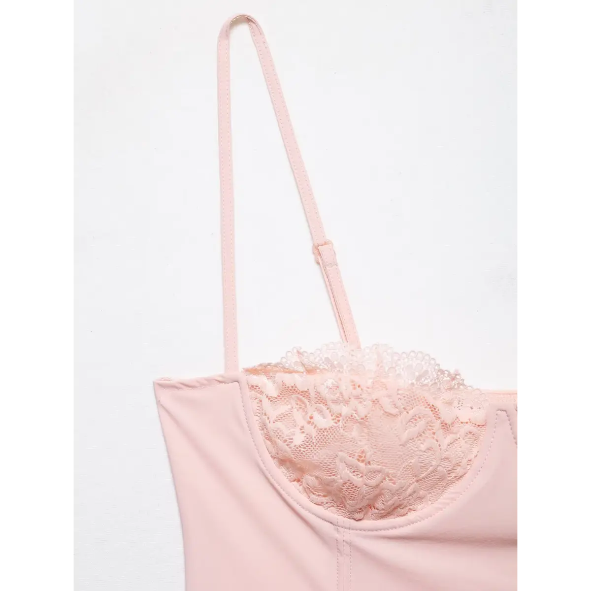 Close-up of the adjustable strap and lace cup edge on the pink camisole.