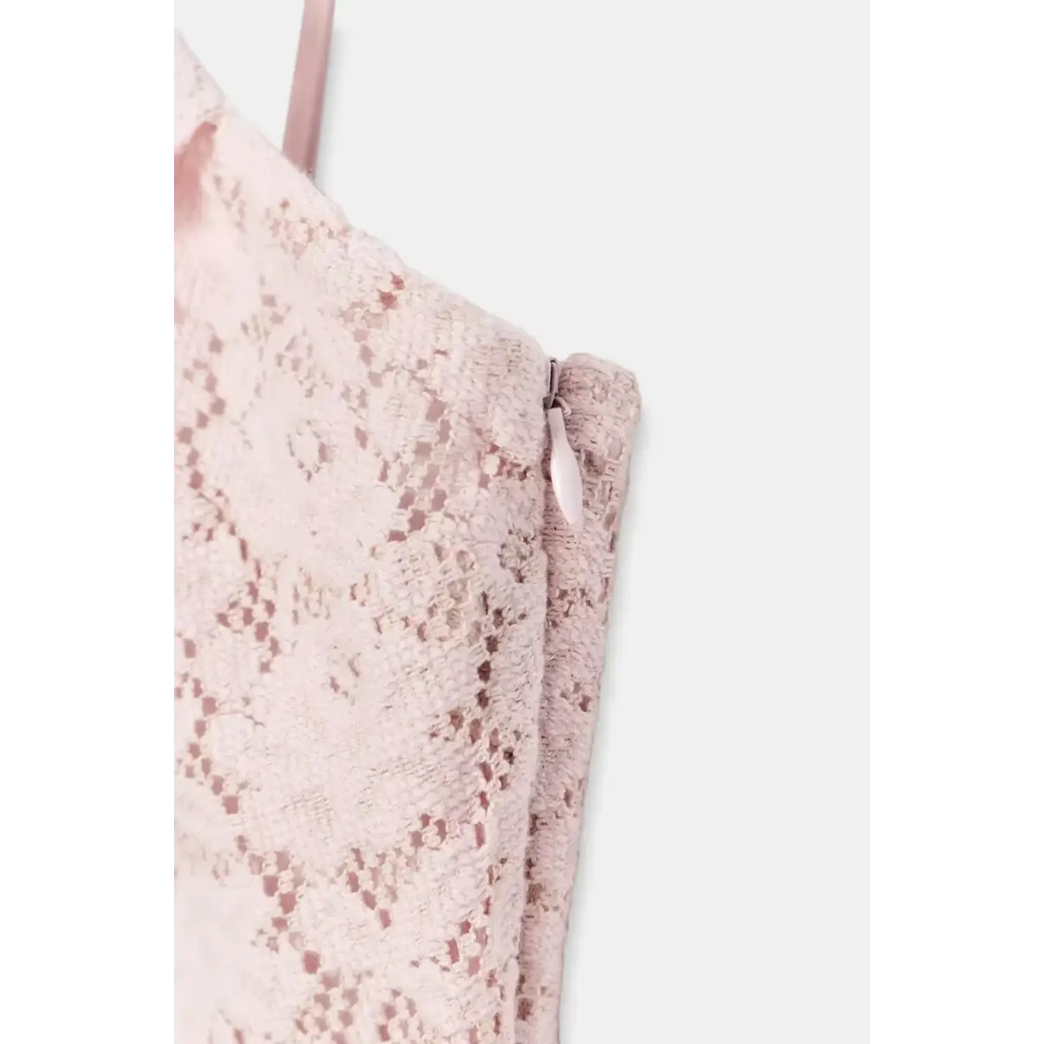 Extreme close-up isolated white background, invisible side zipper pull tab detail of pink mixed lace mini dress