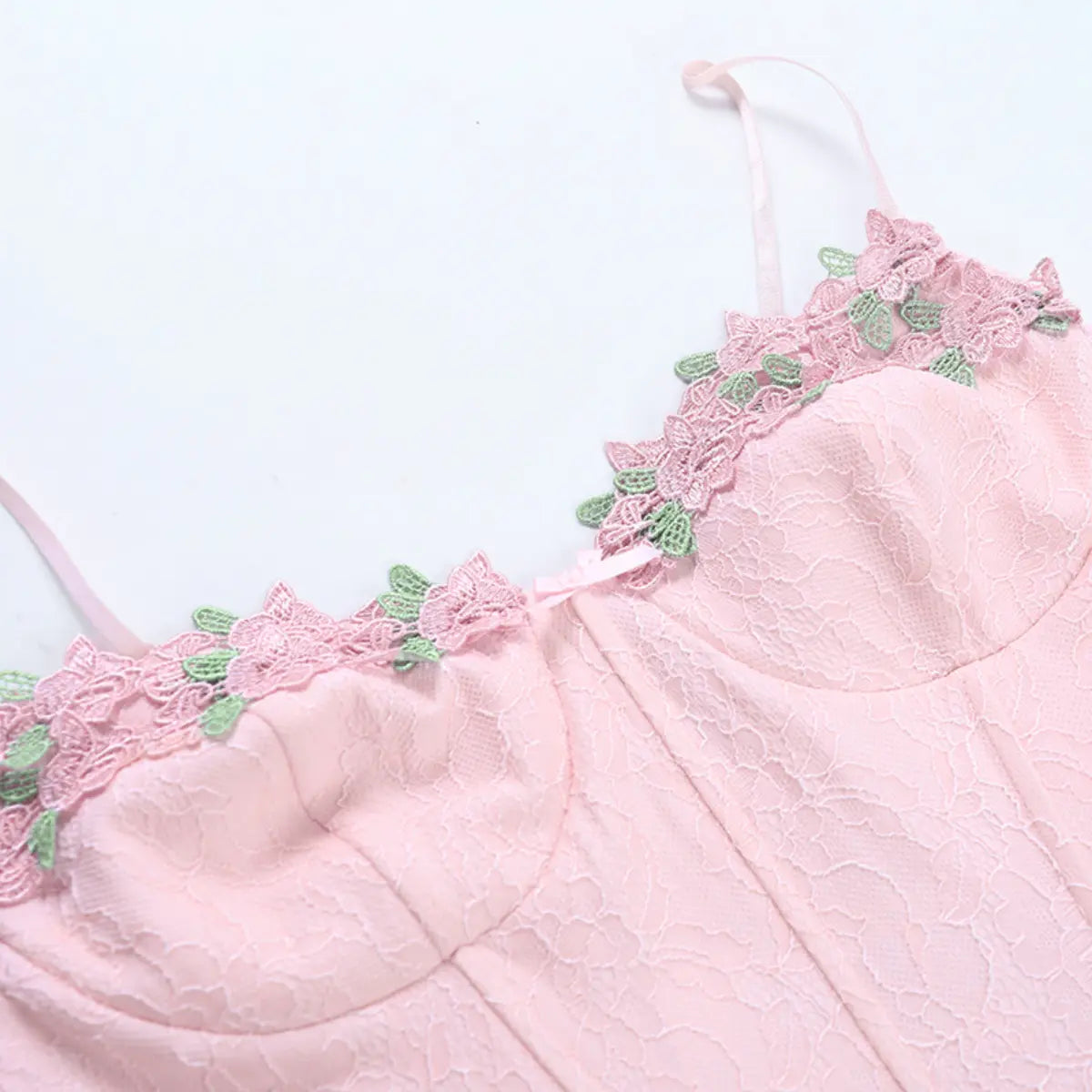 Front view of the pink lace bustier top, showing the sweetheart neckline, floral appliqu, and center bow detail