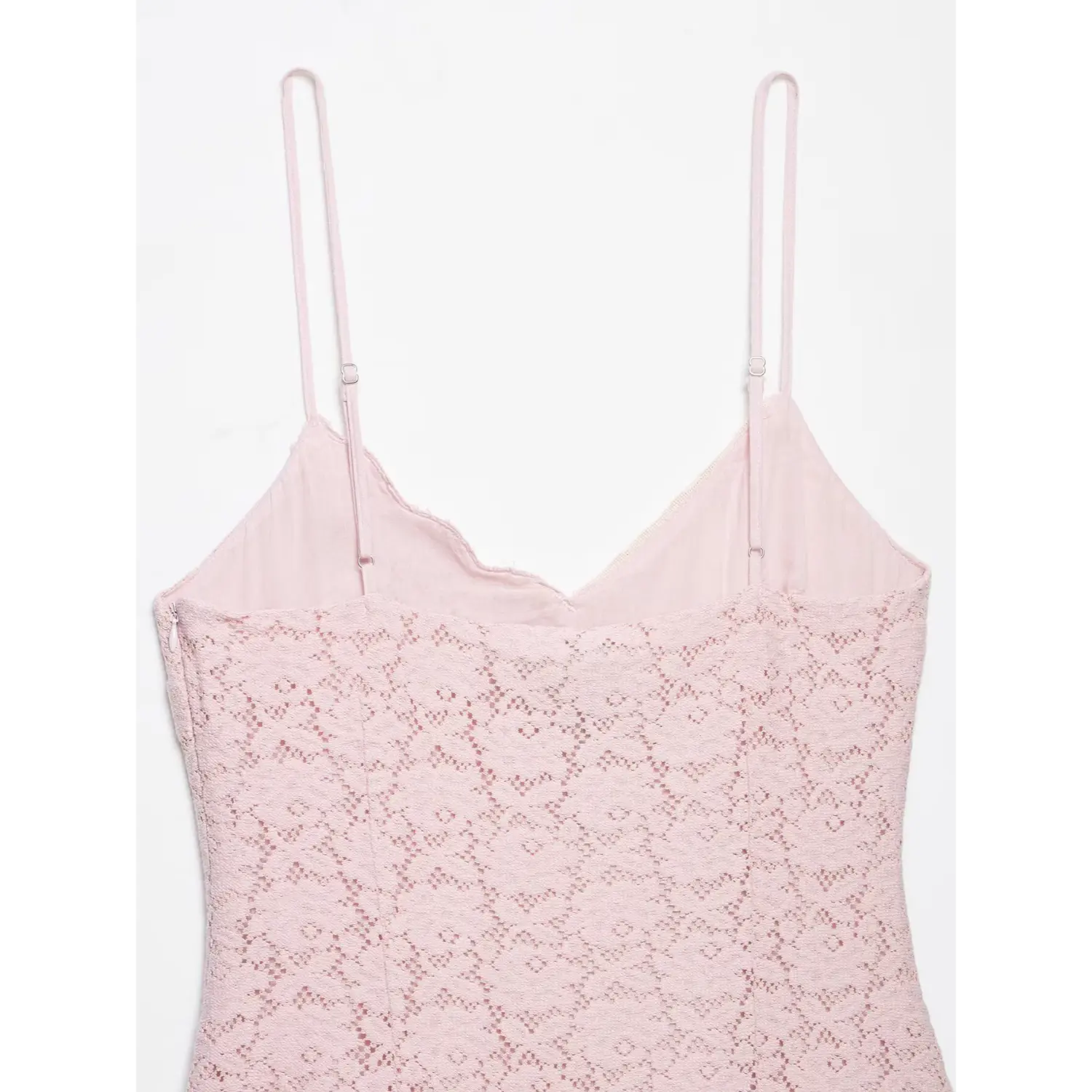 Close-up isolated white background, adjustable slider thin spaghetti straps and scalloped inner lining on the back of pink lace mini dress
