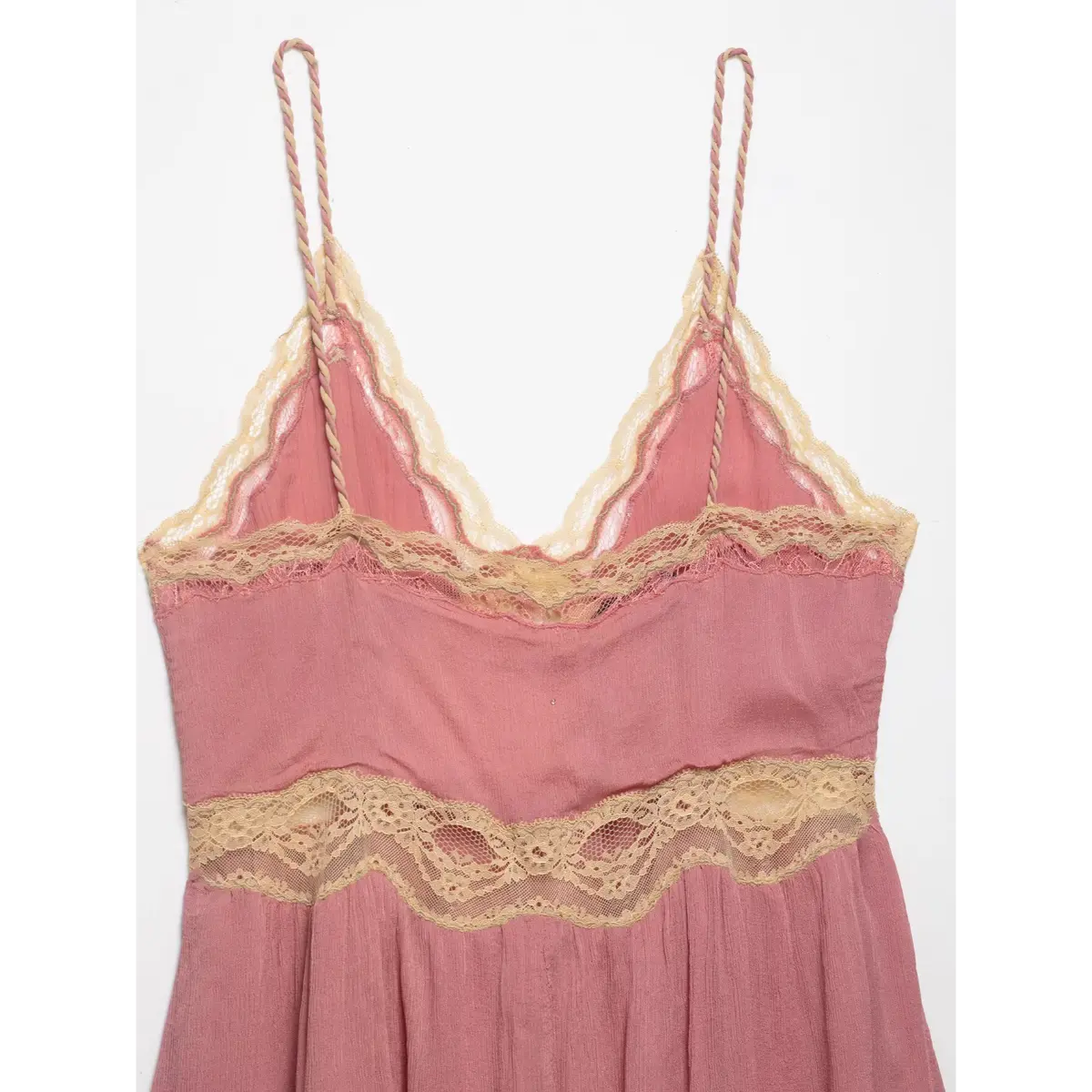 Back view of a pink lace-trimmed peplum cami top, highlighting the lace trim and braided straps.