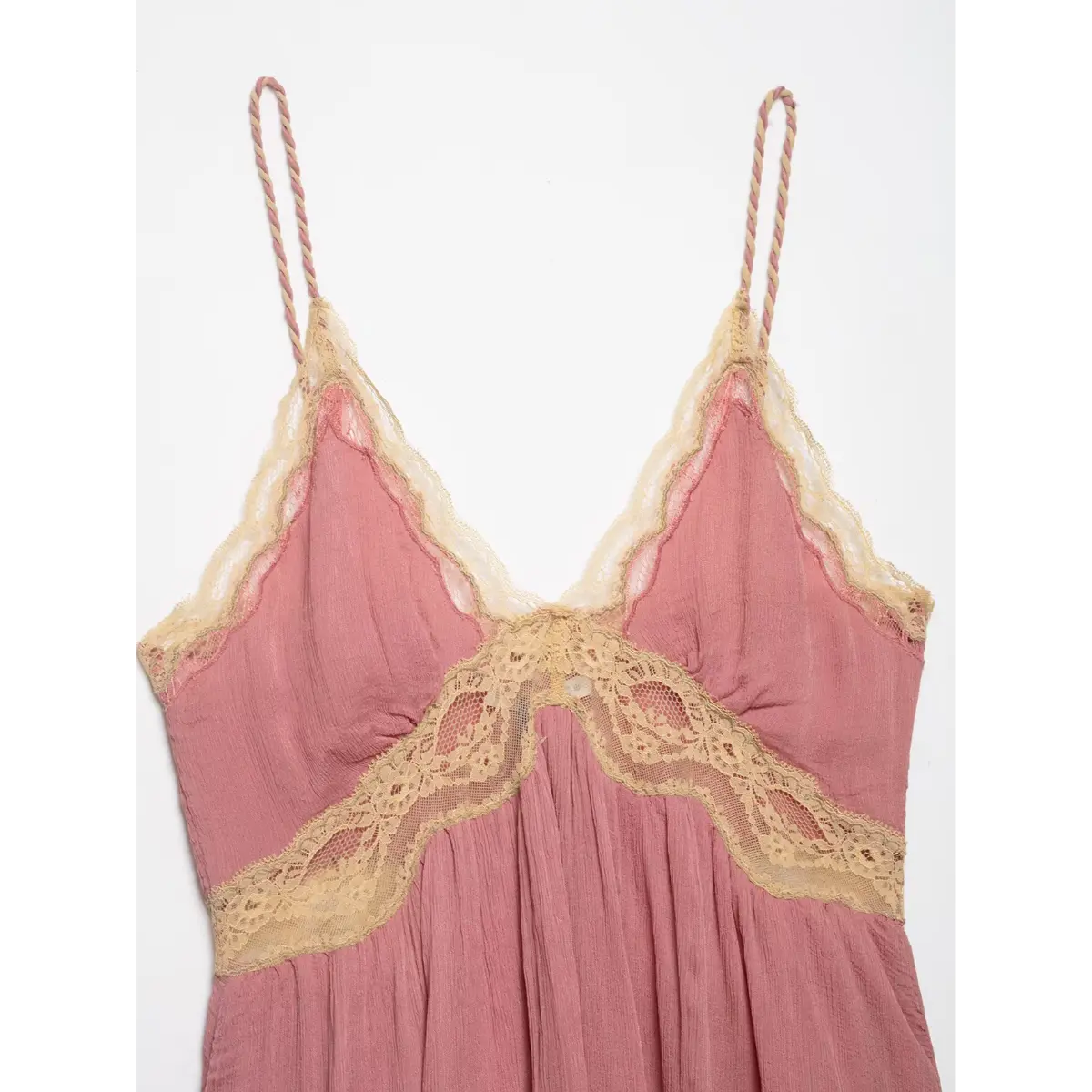 Full front view of a pink lace-trimmed peplum cami top, featuring a V-neckline and braided spaghetti straps.