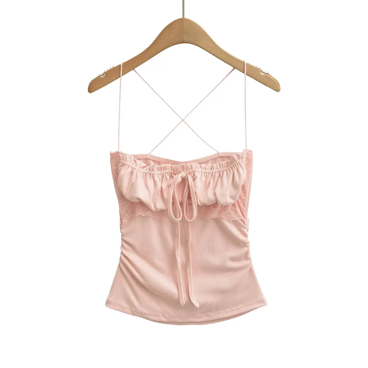 Full view of pink lace-trim cami top on a wooden hanger, featuring crisscross straps and side ruching.
