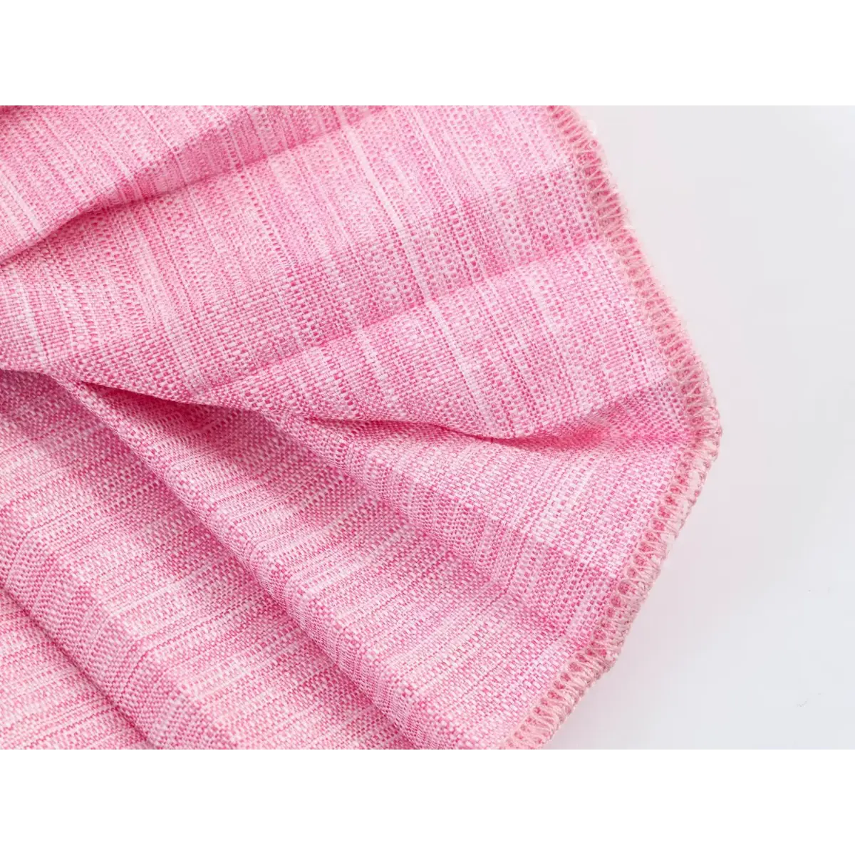 Close-up detail shot of the fabric edge and stitching on a pink linen blazer dress, showing the finished hem and woven texture.