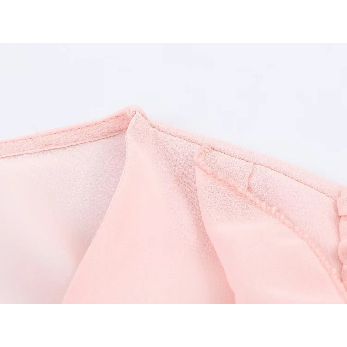 Close up of stitching and ruffle seam construction on pink chiffon maxi dress
