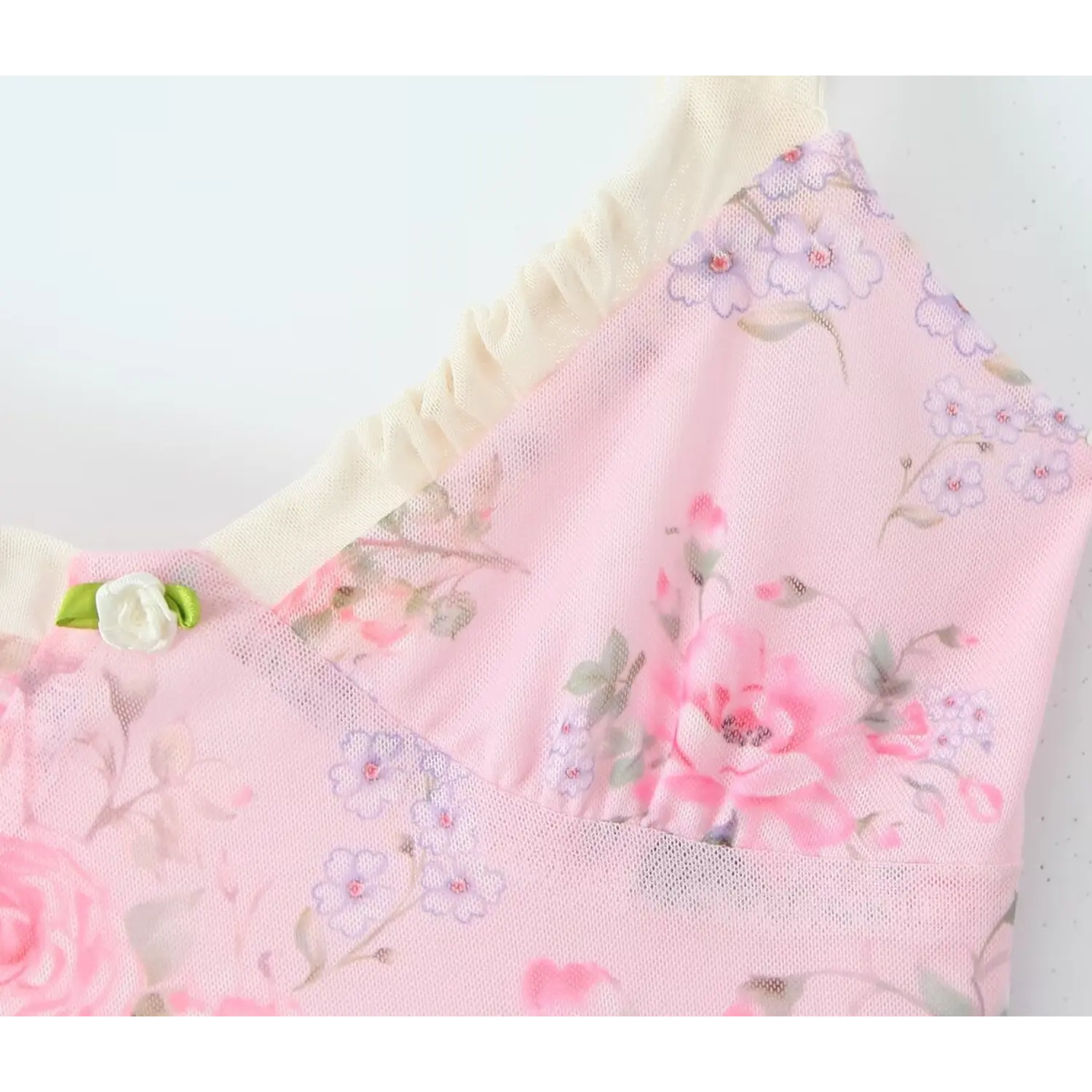 Macro close‑up of small 3d rose applique on v‑neck bust, pink mesh fabric with romantic rose floral print