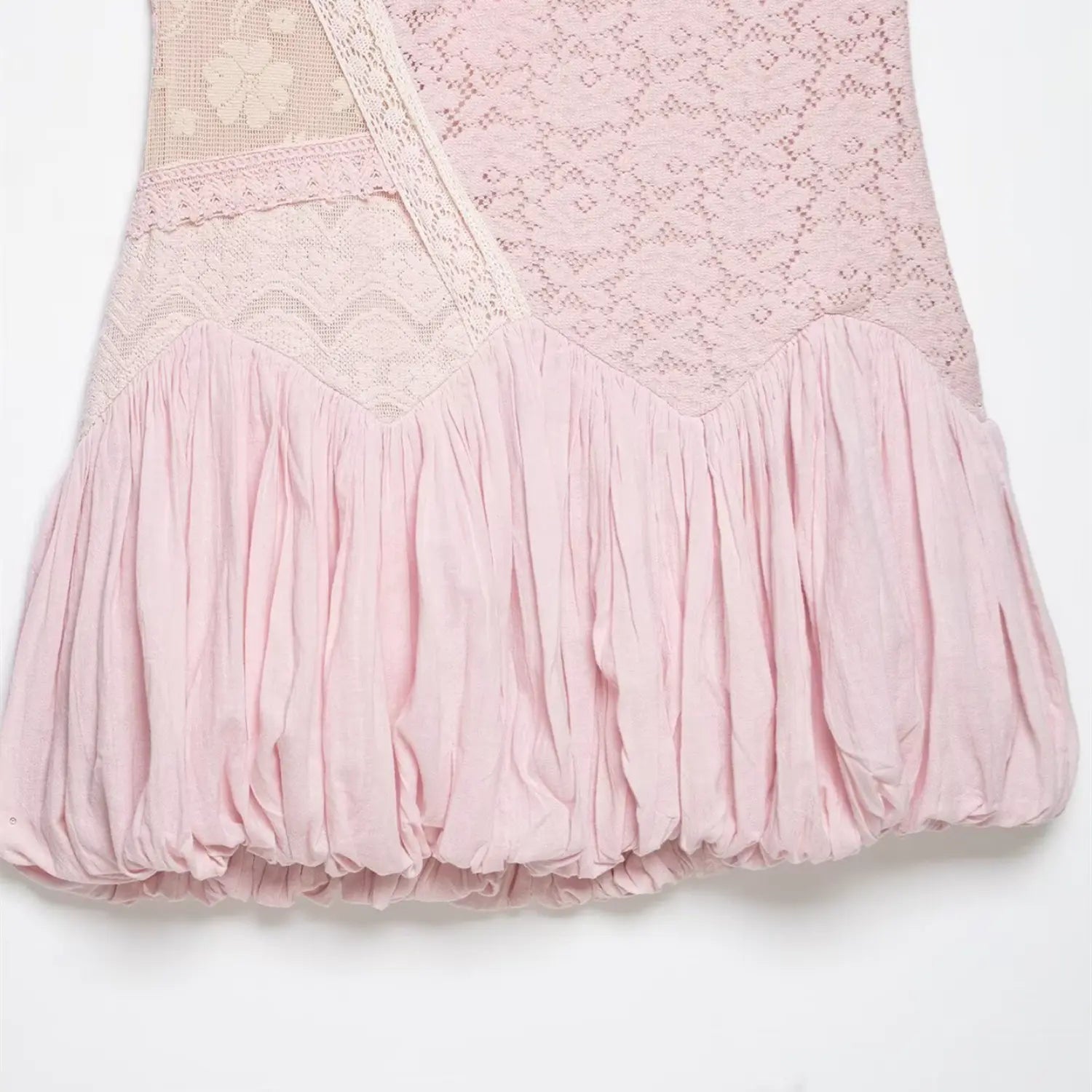 Close-up isolated white background, mixed floral lace waist mesh cutout and pleated bubble skirt stitching detail of pink mini dress