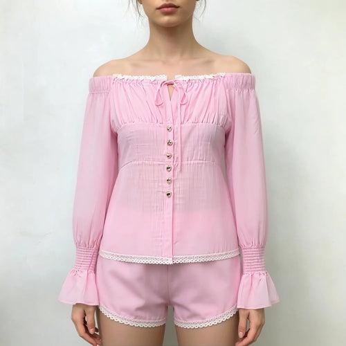Model front view, pink off‑shoulder long sleeve top and matching shorts set, white lace trim, heart metal buttons, smocked flared cuffs