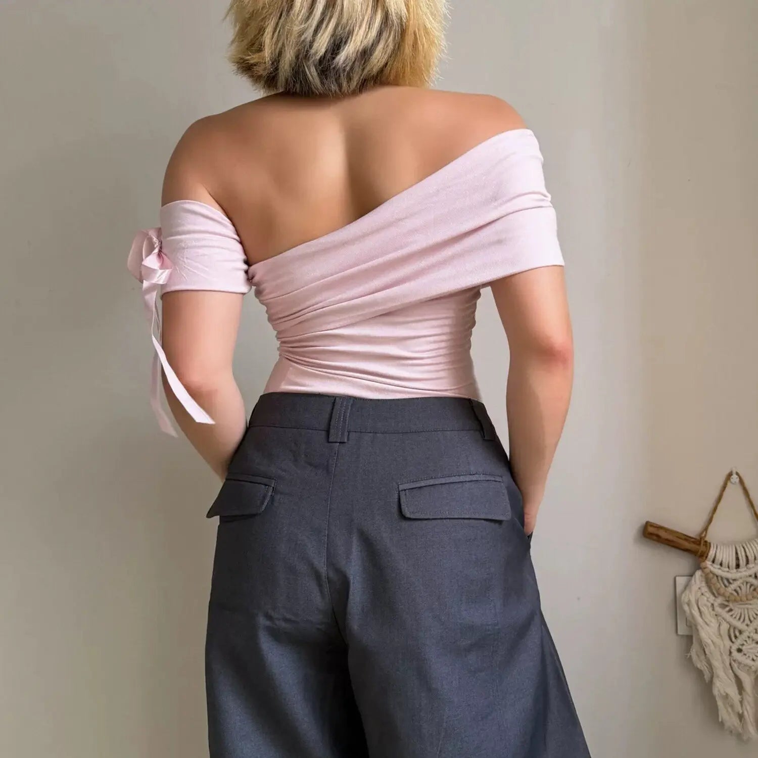 Pink off shoulder ruched top with bow sleeve matched with charcoal gray wide leg cargo pants, back side view outfit shot