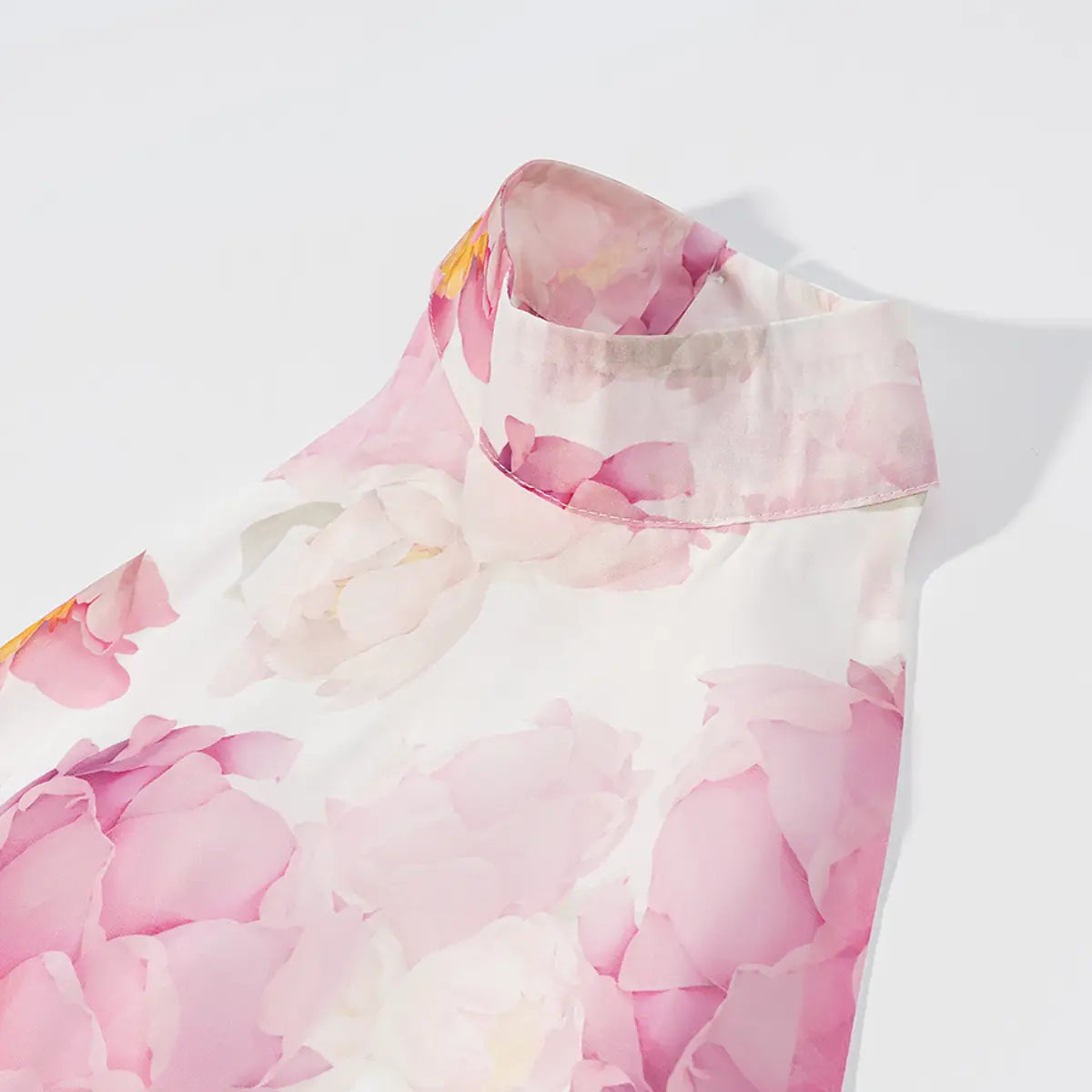 Close-up detail shot of the high halter neckline on a pink peony floral dress, showing the folded collar and stitching.