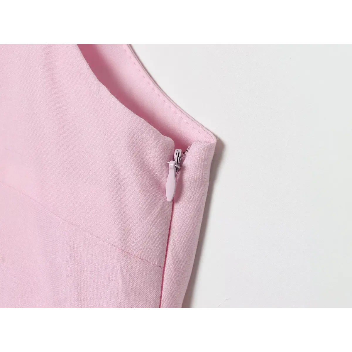 Close-up of the top's side zipper with a matching pink pull.