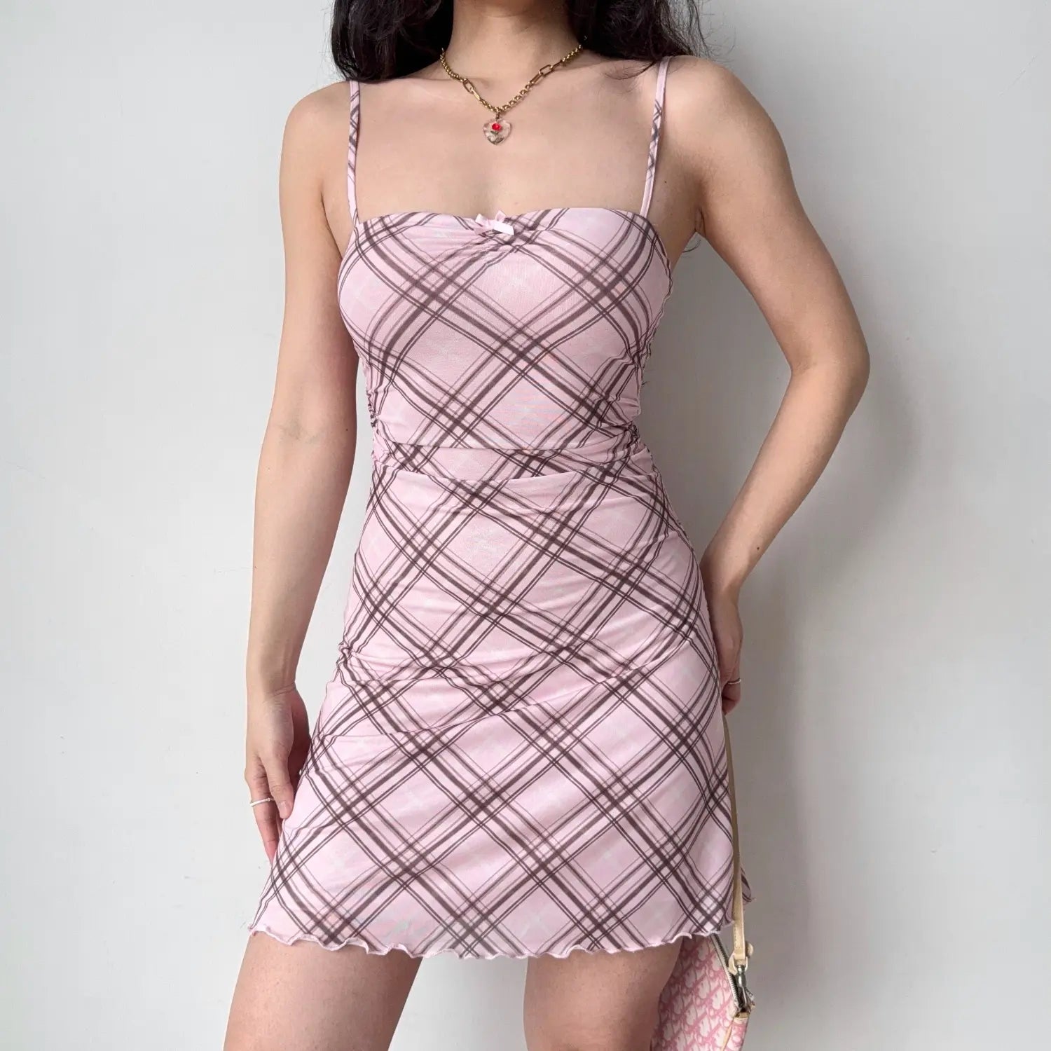 Female model wearing pink brown diagonal check mesh slip dress, ruched waist slim fit mini dress with ruffle lettuce hem