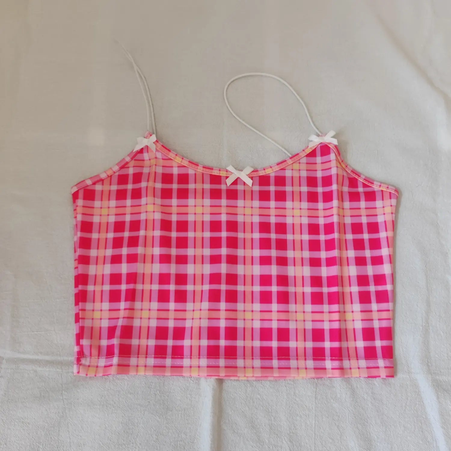 Flat lay front view pink plaid cropped cami top with three white small bow details