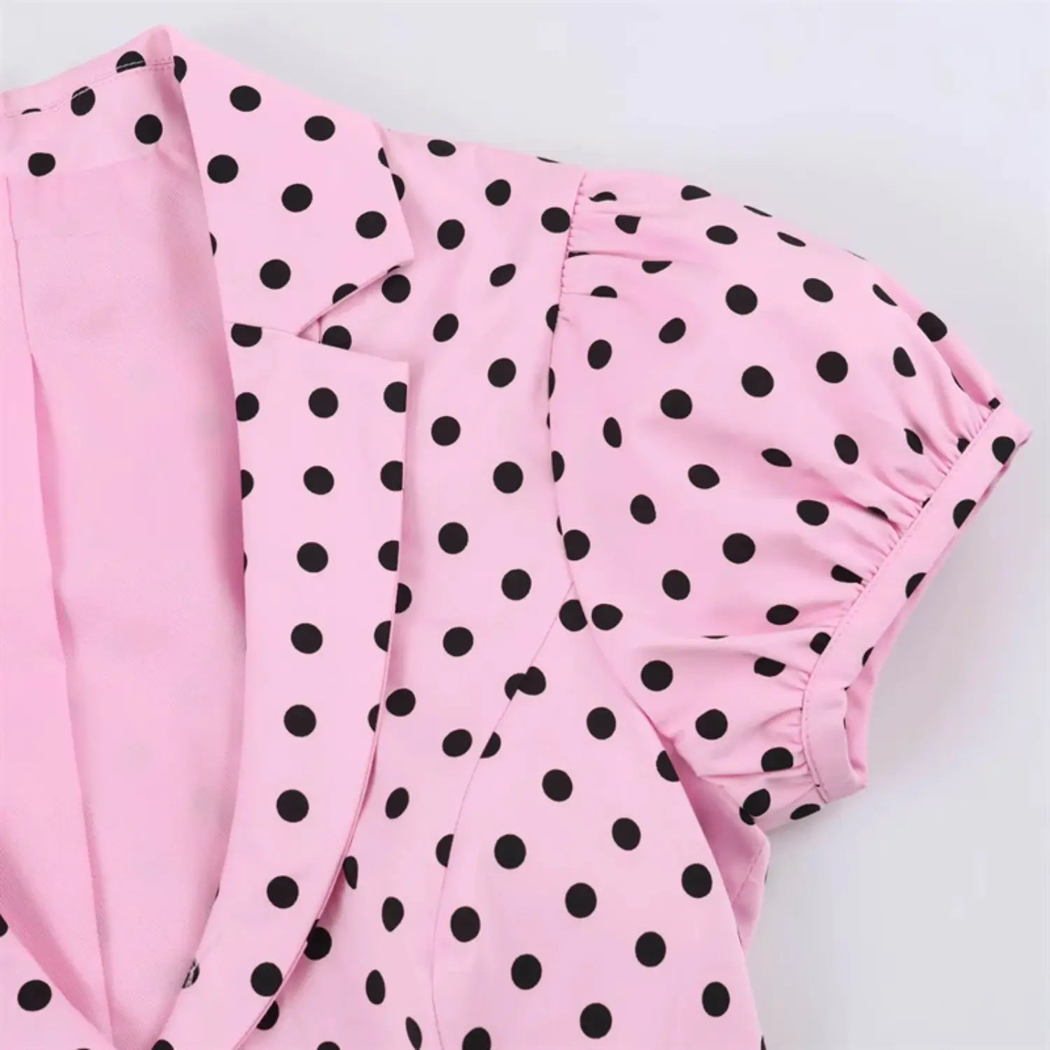 Shoulder joint macro shot, lapel edge stitching, gathered elastic puff sleeve cap, polka dot fabric draping detail