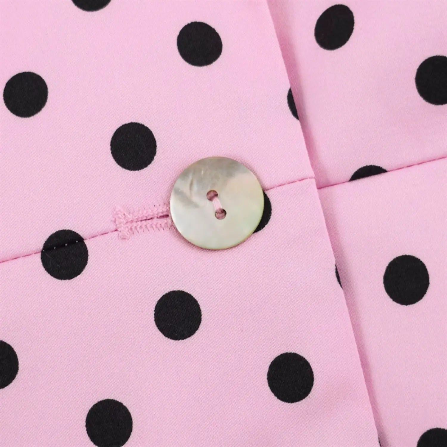 Front placket round shell button close-up, two-hole natural nacre button, pink thread reinforced stitching