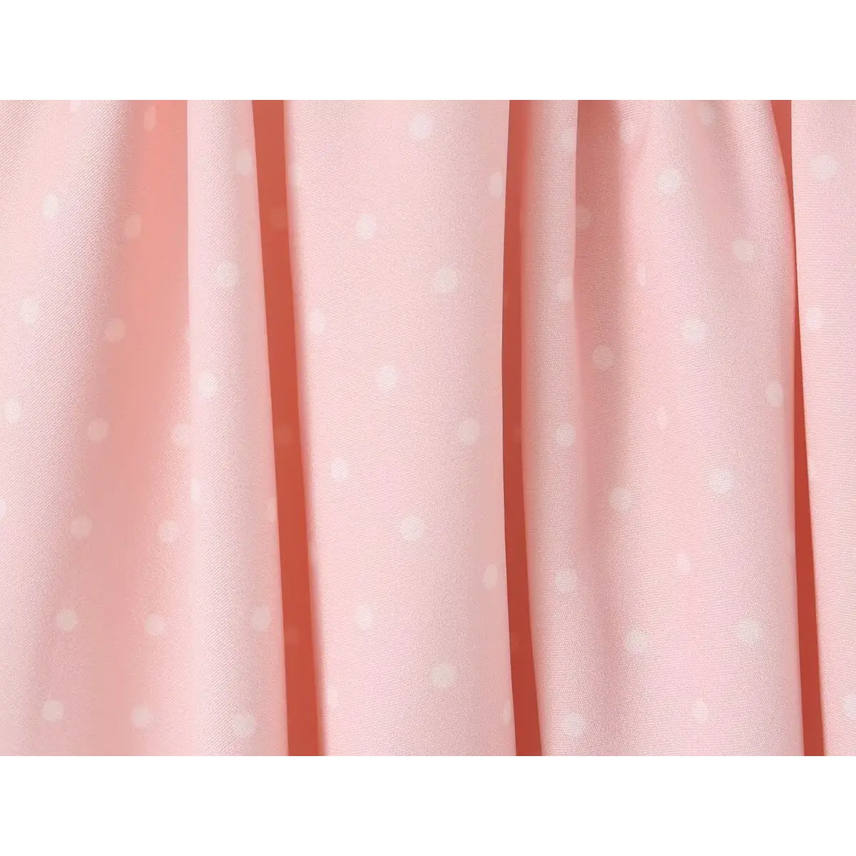 Close-up of the pink polka dot fabric texture on a dress.