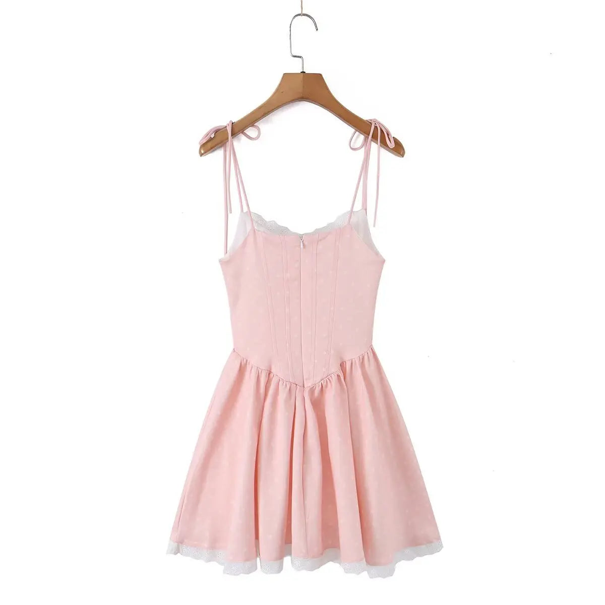 Back view of a pink polka dot corset-style dress hanging on a wooden hanger.