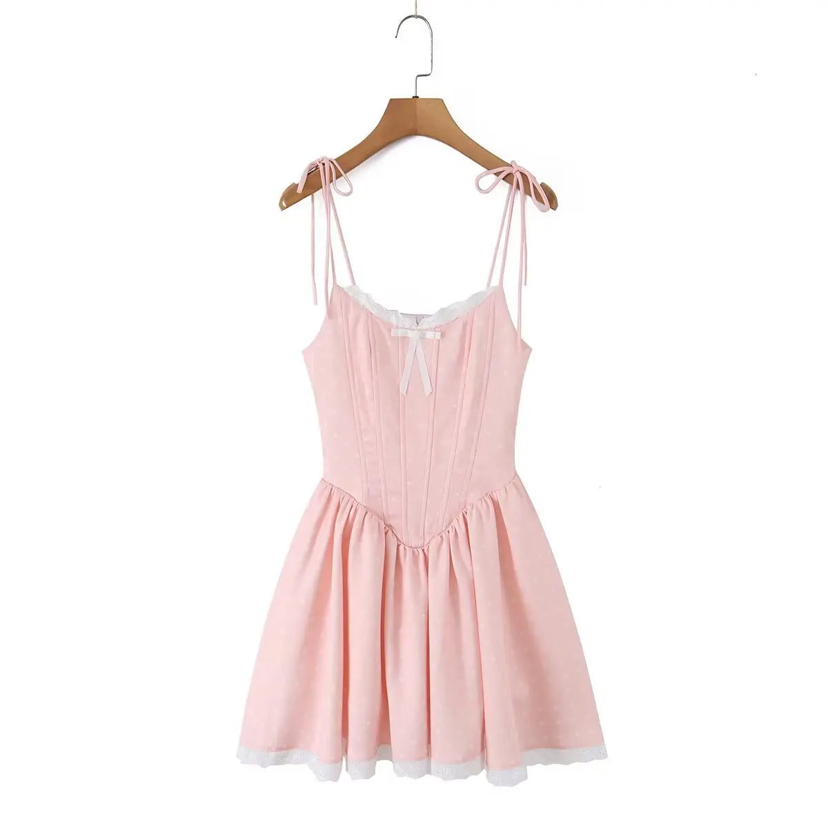 Front view of a pink polka dot corset-style dress hanging on a wooden hanger.