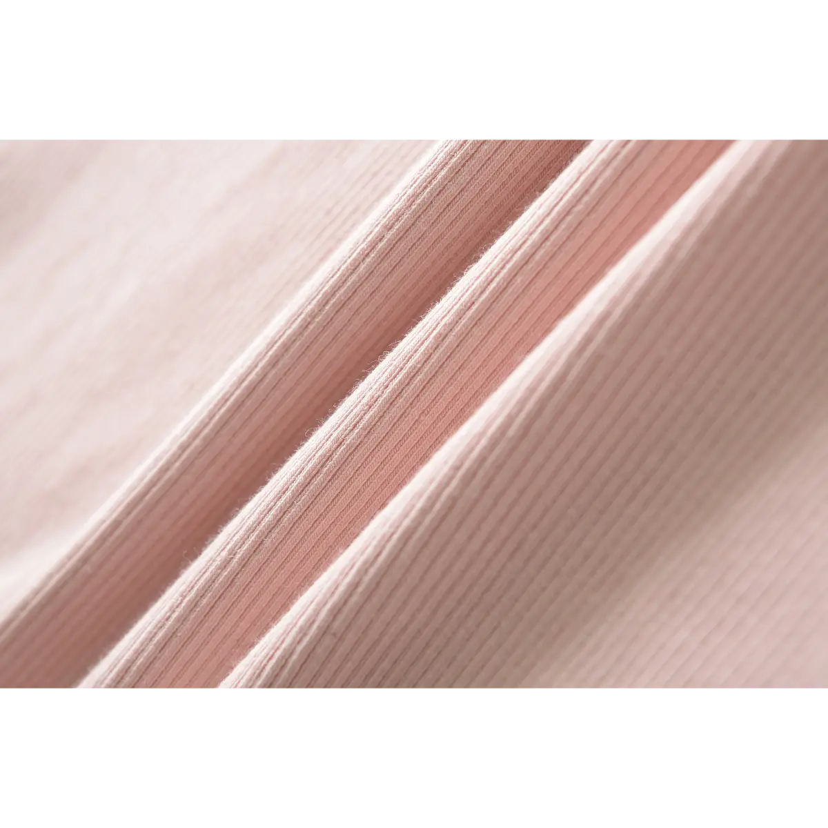 Close-up of the ribbed texture of a pink dress fabric, showing the fine knit details.