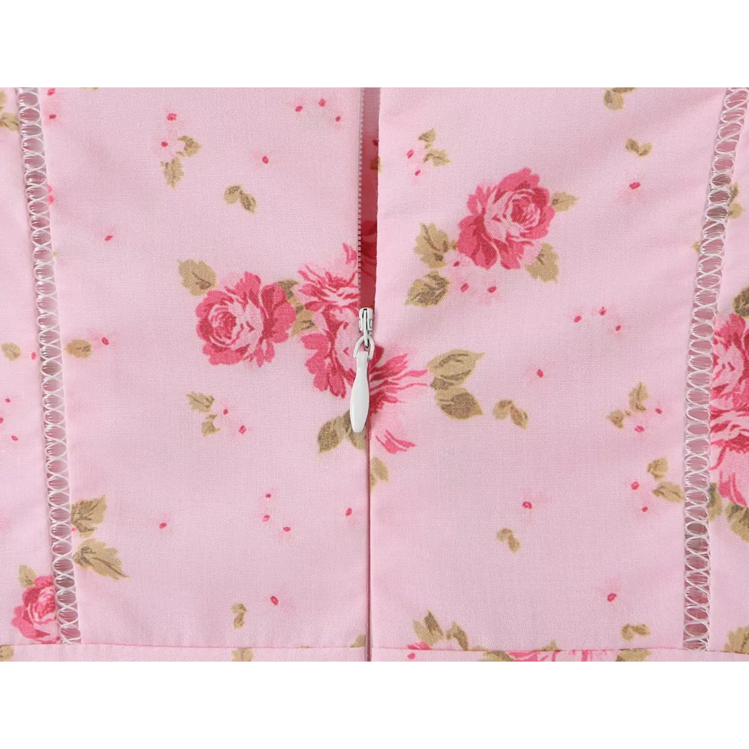 Close-up back bodice shot, hidden invisible center back zipper, vertical hollow eyelet lace stitching structured corset seaming, light pink base all-over vintage pink rose tiny floral print