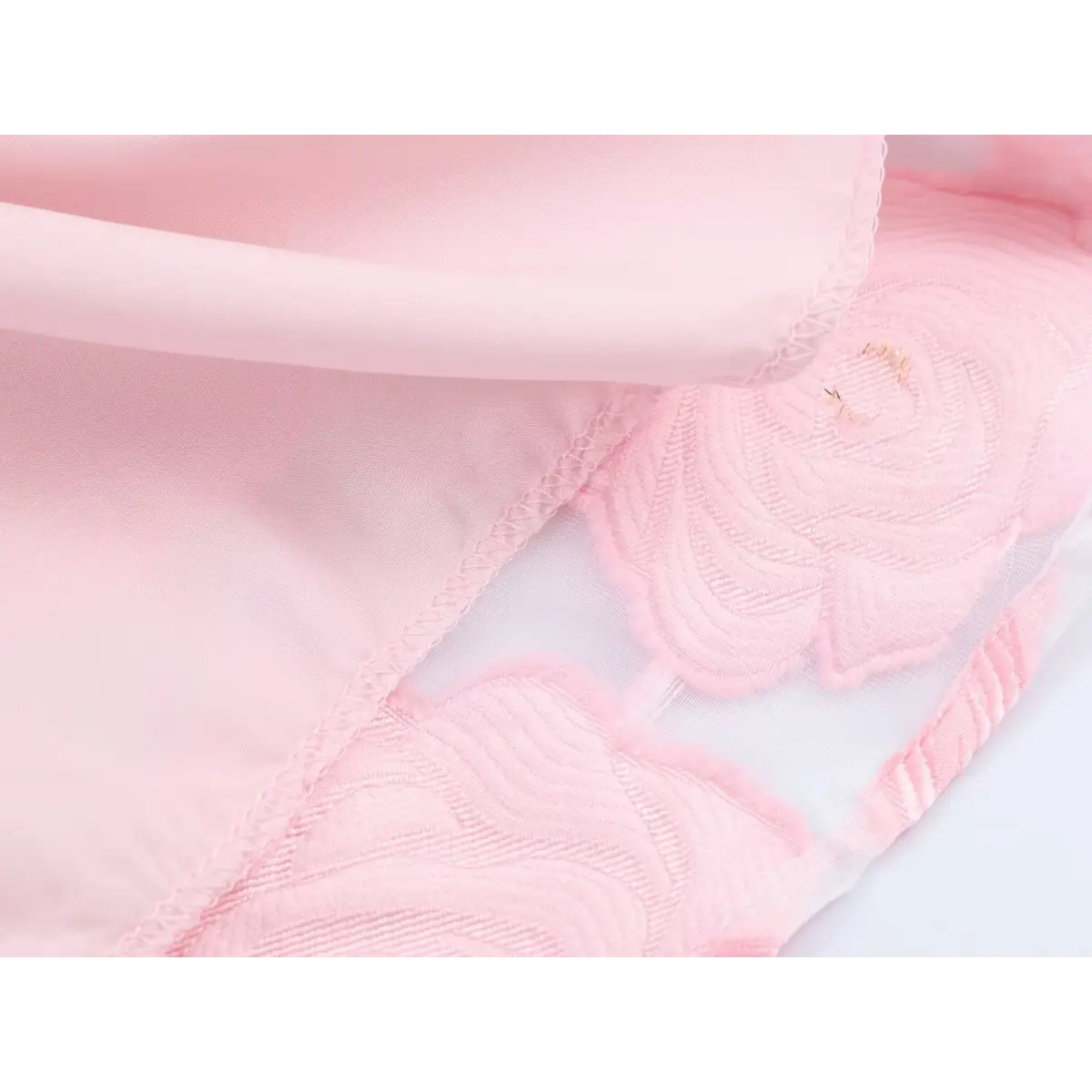 Close-up detail of the inner lining and seam construction on a pink rose-embroidered organza sundress.