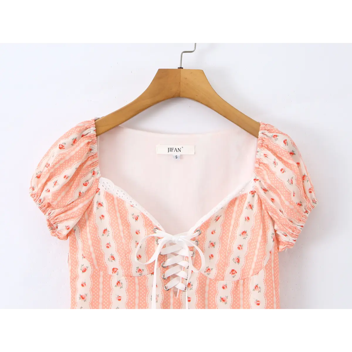 Close-up of the sweetheart neckline with lace trim and corset-style lace-up closure on the pink rose print dress.