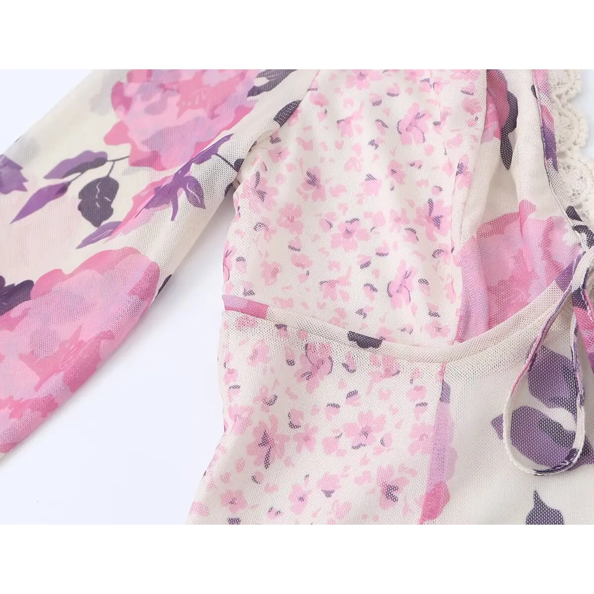 Close-up of the dress's bodice and sleeve, highlighting the floral print, the fitted panel construction, and the sleeve seam.