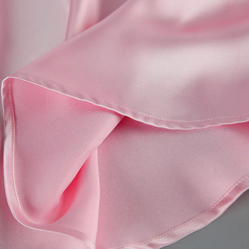 Macro close-up of pink satin fabric and hem stitching
