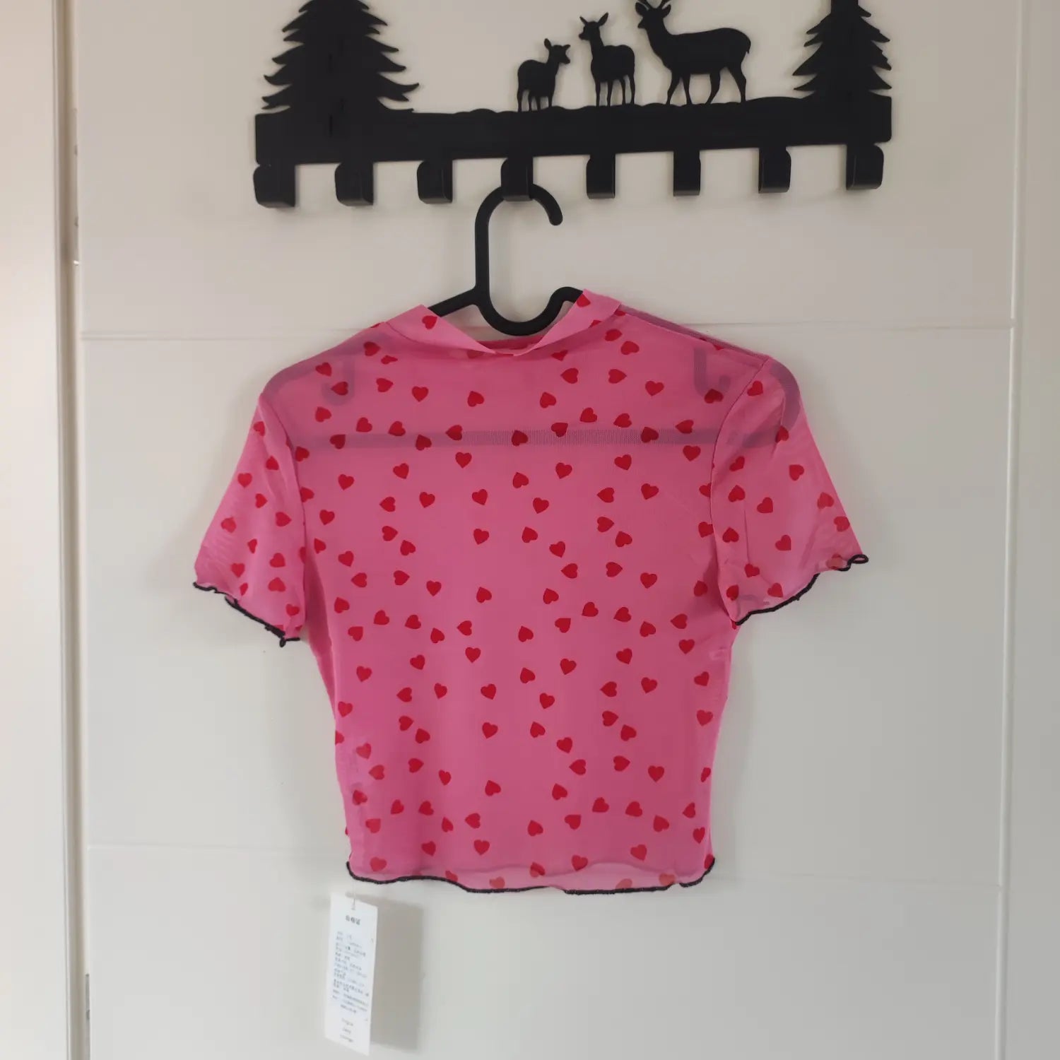 Hanging back view pink red heart print short sleeve mesh top with black lettuce edge