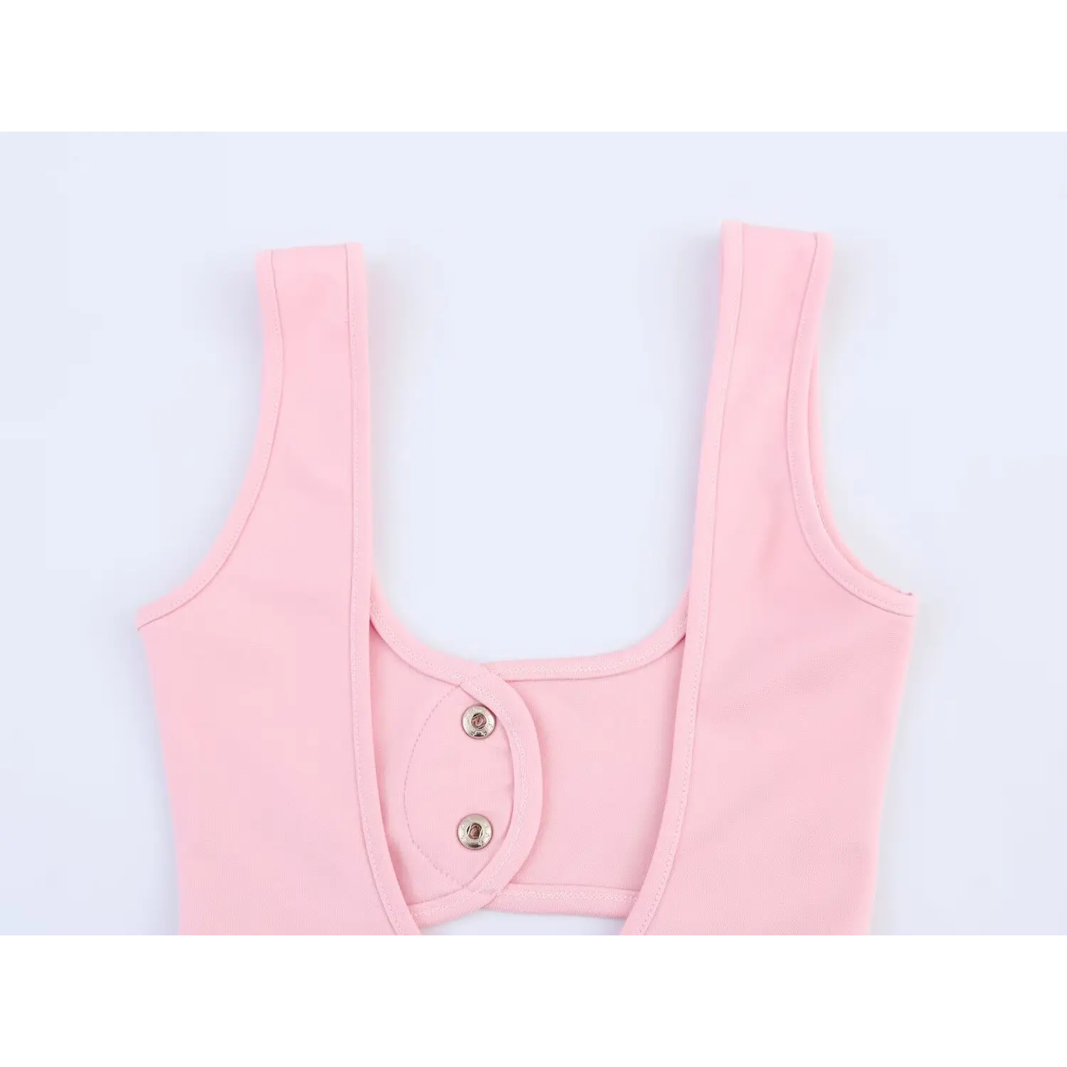 Back view detail of pink sleeveless cutout mini dress with double snap buttons, white background