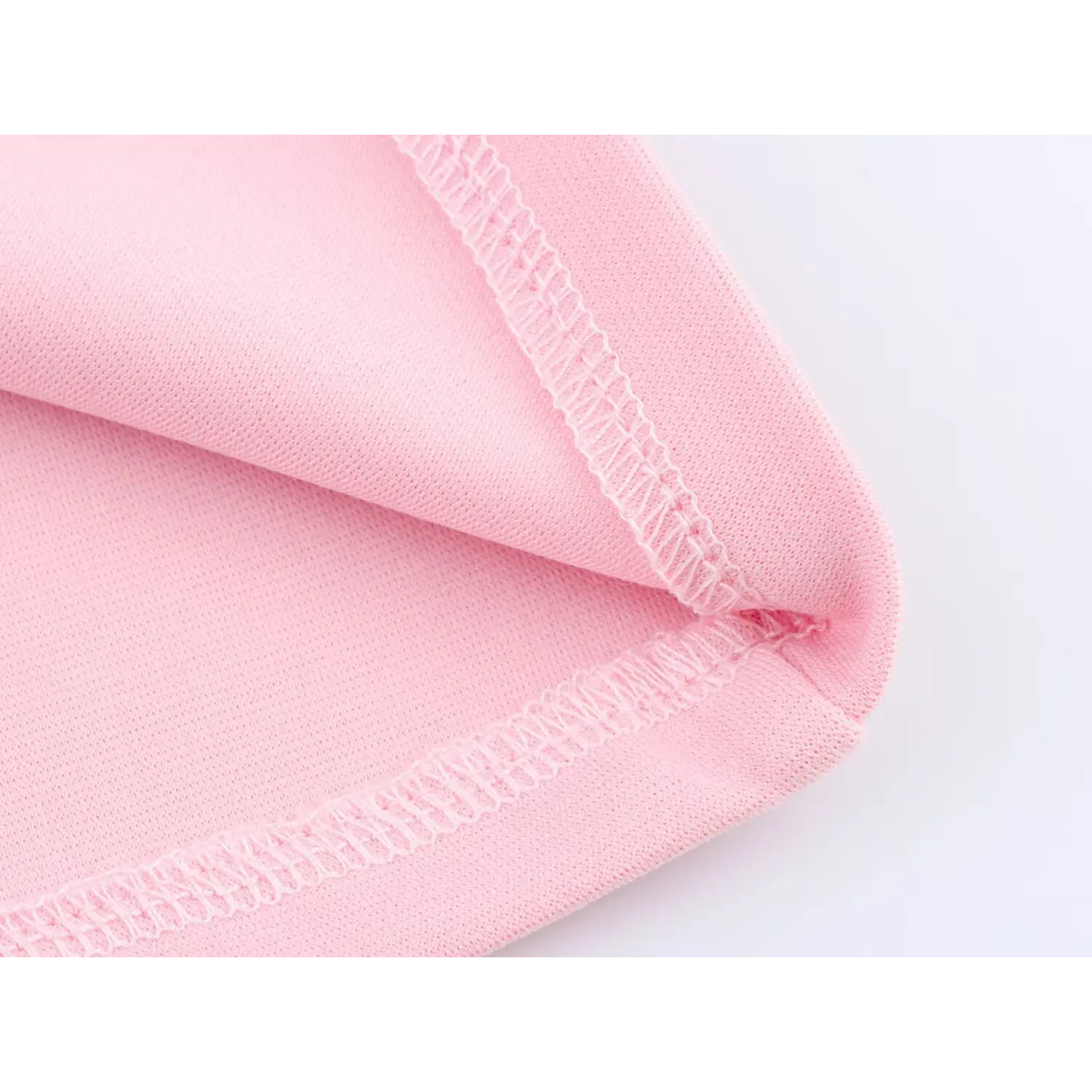 Close-up of pink stretch knit fabric with neat finished hem stitching detail