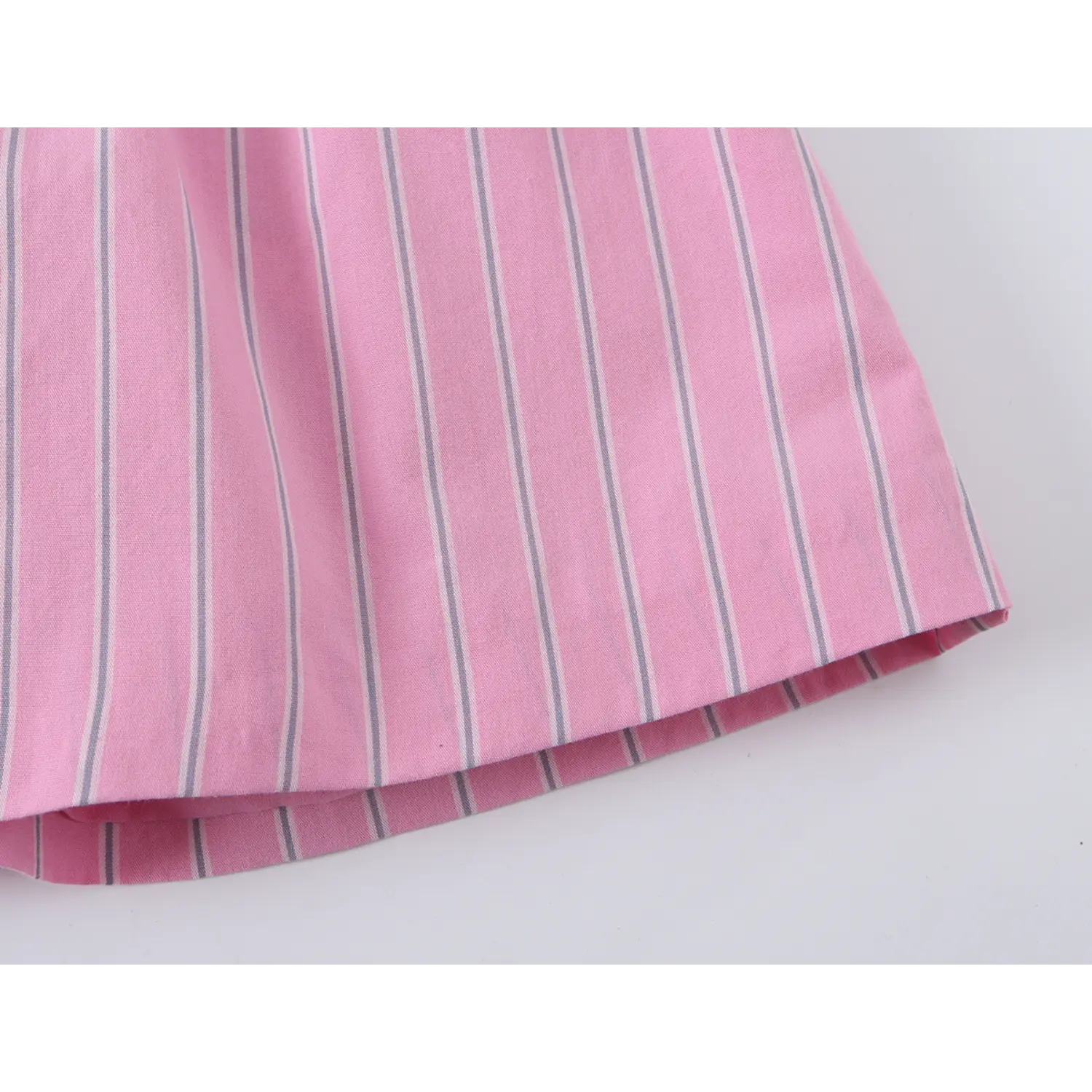 Wide partial shot of full flared peplum hem, straight finished bottom edge