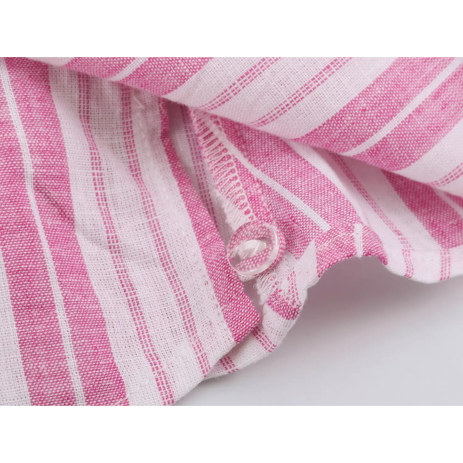 Fabric close-up of lightweight textured vertical stripe material and finished overlock inner stitching